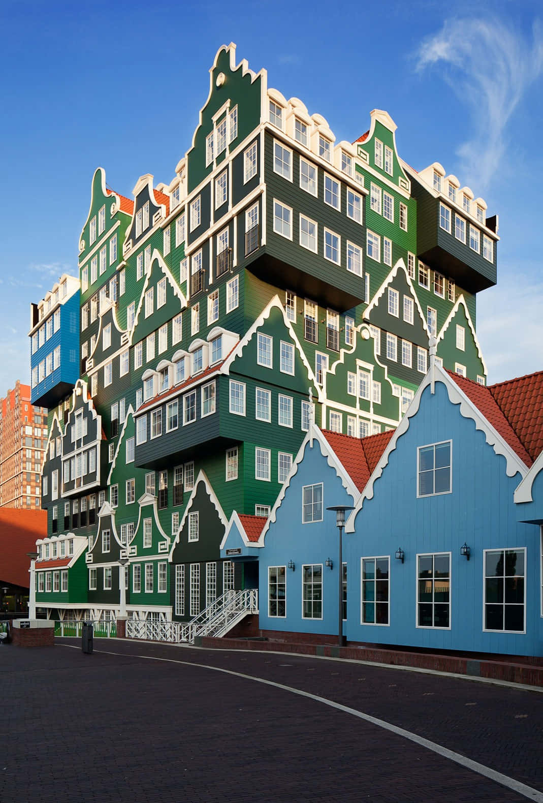 Building 桌布 壁紙 — 一座引人注目的現代建築，設計成類似堆疊的荷蘭山牆房屋，綠色和藍色，在清澈的藍天下。