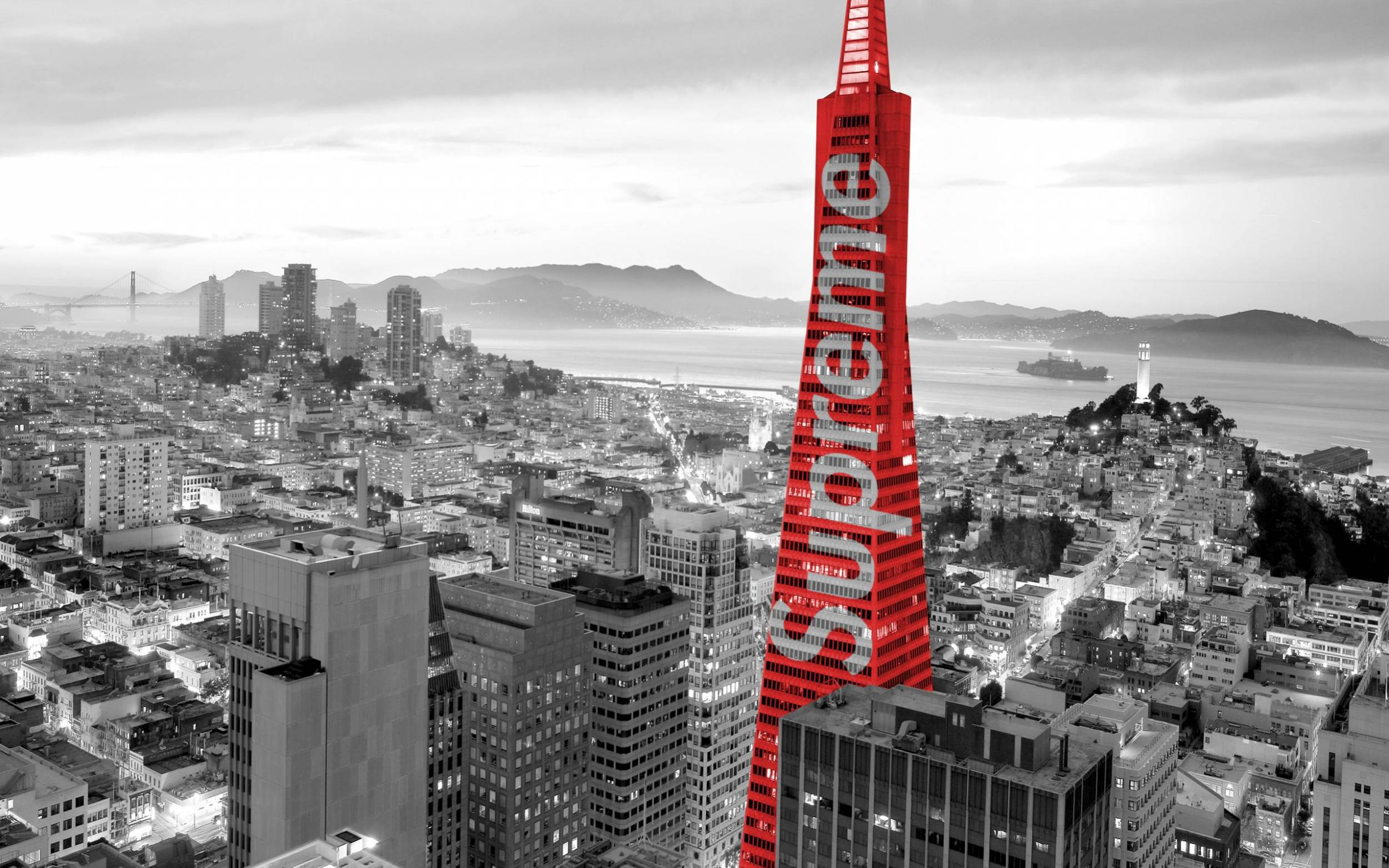 supreme 桌布 壁紙 — 一座引人注目的紅色摩天大樓帶有「Supreme」字樣，在黃昏時分主導了黑白舊金山的天際線。