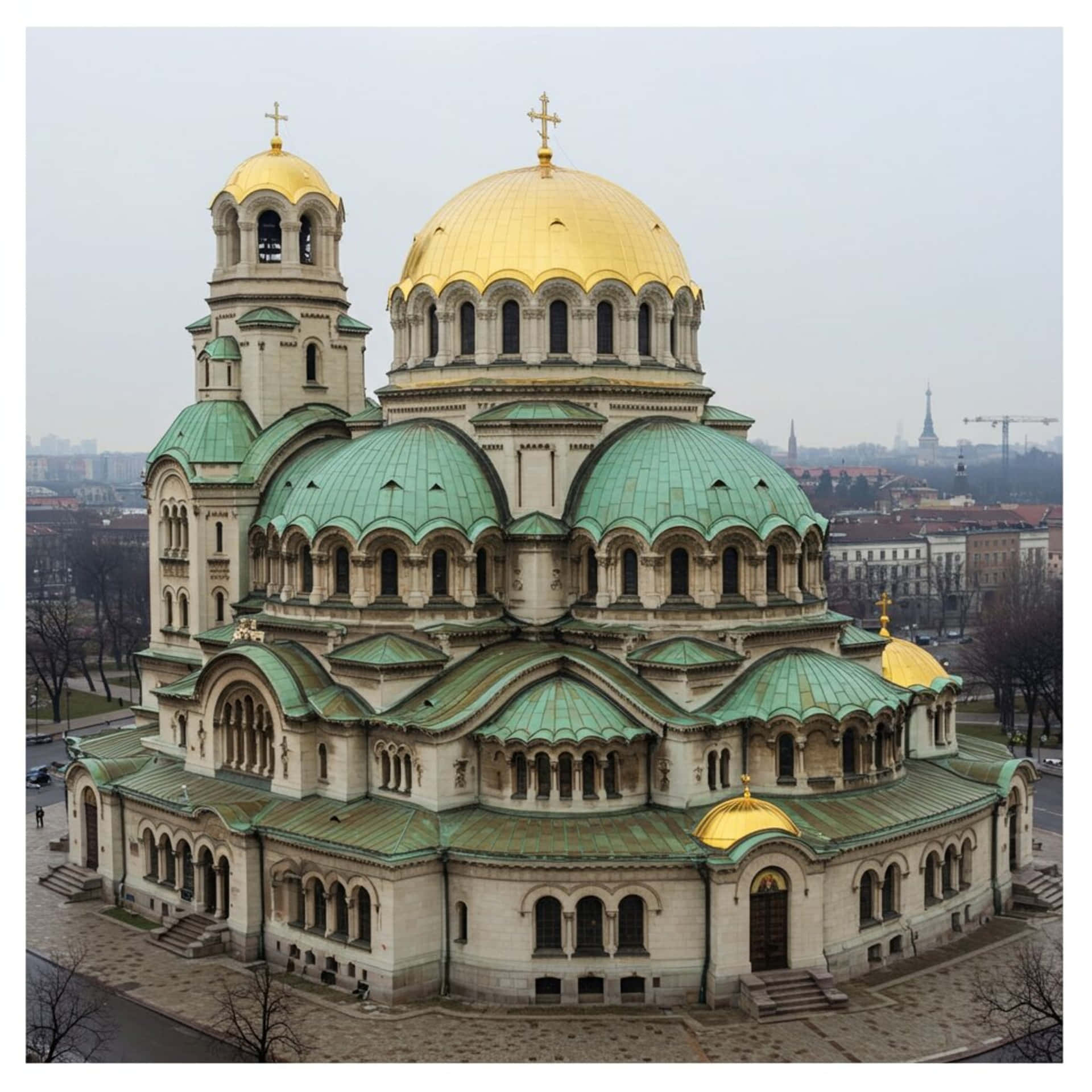 Bulgarian Basilica 壁紙 — 一座擁有金色和綠色圓頂的大教堂在陰天籠罩下的城市景觀中聳立。