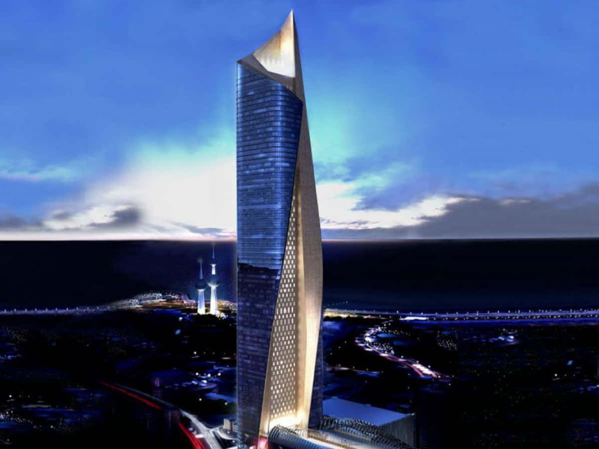 Building 桌布 壁紙 — 一座未來主義的摩天大樓，頂端閃耀著金色尖頂，在黃昏時分矗立於沿海城市之上，映照著深藍色的天空和海洋。