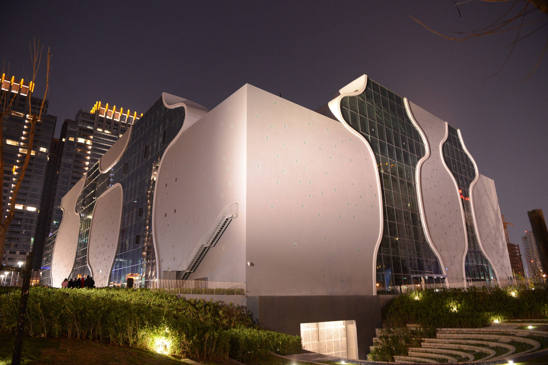 一座在都市環境中夜間照亮的現代建築。