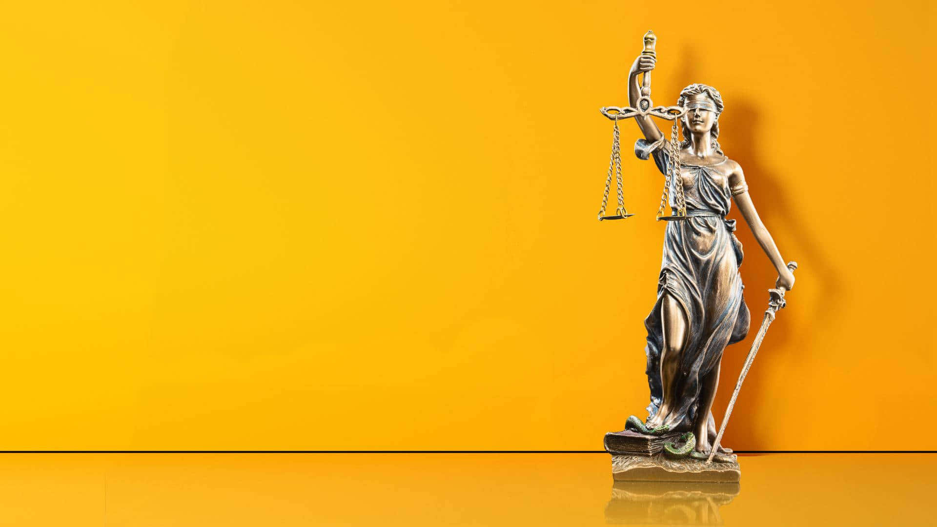 Justice 桌布 壁紙 — 一座正義女神的銅像站在鮮黃色背景前，手持天秤和劍。