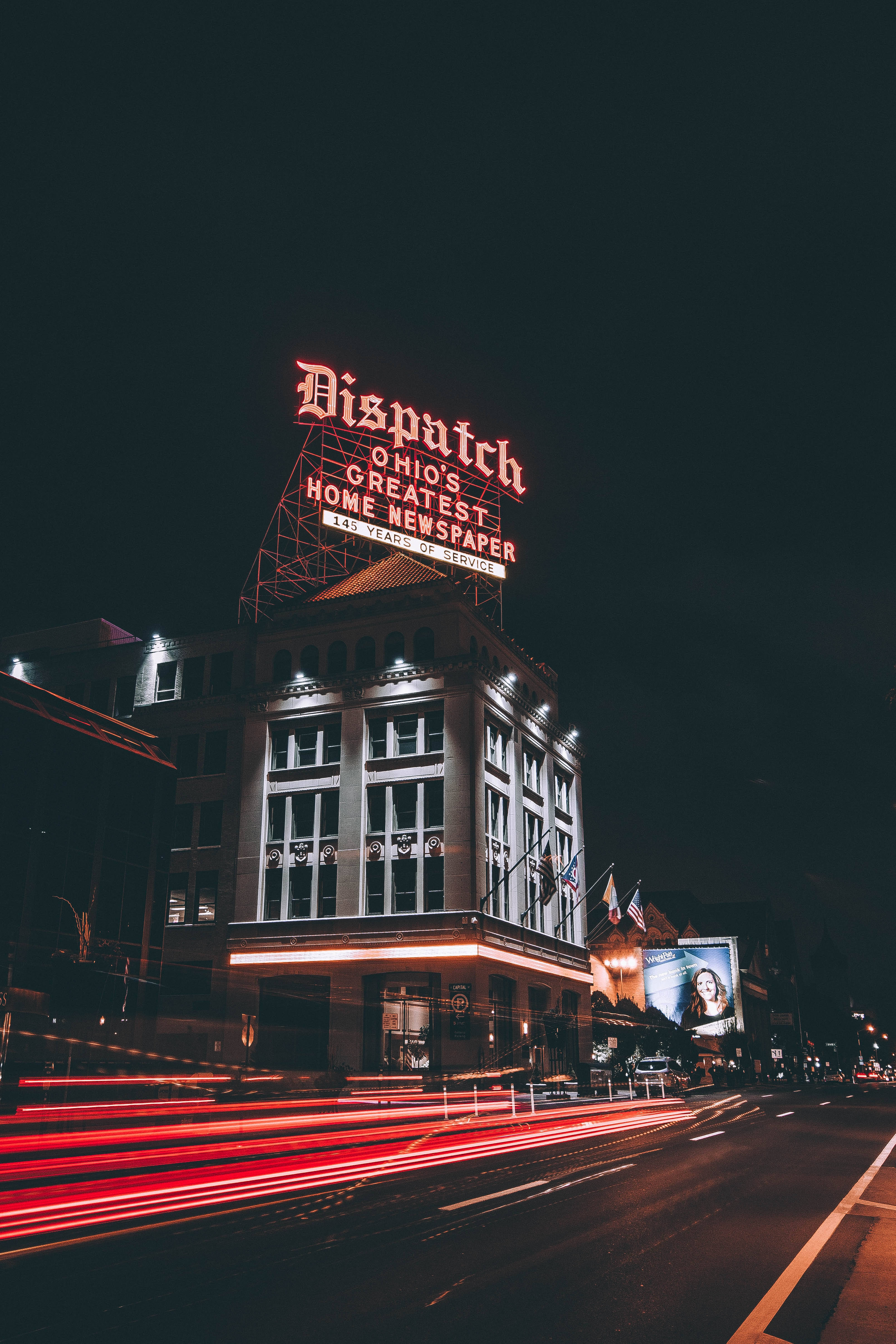 Ohio 桌布 壁紙 — 一座歷史建築在夜晚被發光的紅色「Dispatch」標誌照亮，下方有來往車輛留下的紅色光軌。