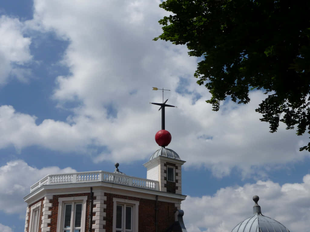 Building 桌布 壁紙 — 一座歷史悠久的磚造建築，帶有白色欄杆和圓頂上的紅色球體，天空部分多雲，呈現藍色。