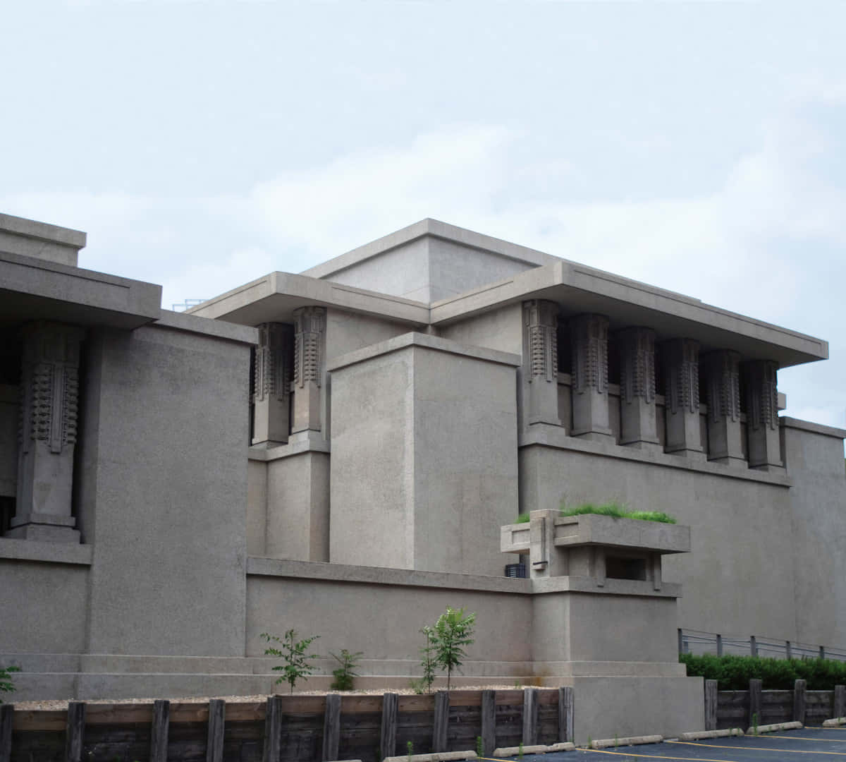 建築 桌布 壁紙 — 一座灰暗的混凝土建築，具有幾何線條和垂直百葉窗，在陰天天空下。