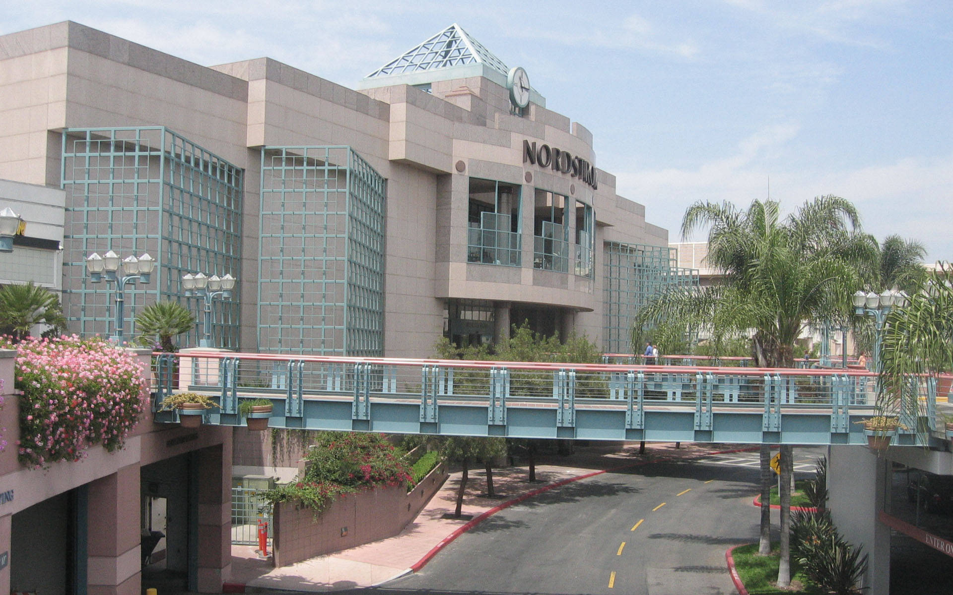 加州 桌布 壁紙 — 一座現代化的Nordstrom建築，玻璃幕牆和行人天橋，在清澈的藍天下。