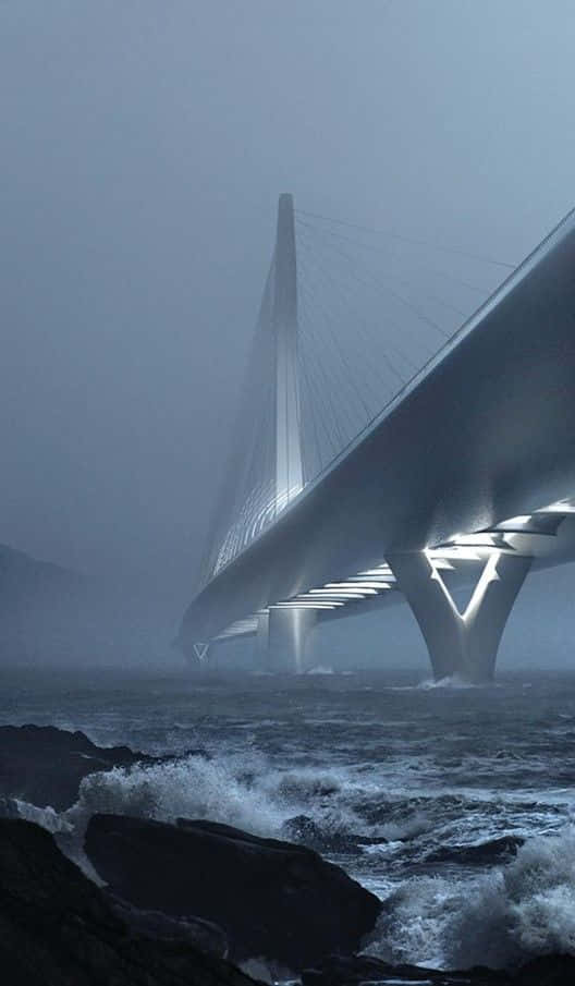 bridge 桌布 壁紙 — 一座現代斜張橋從霧中浮現，下方是波濤洶湧的海浪拍打著暗色岩石。