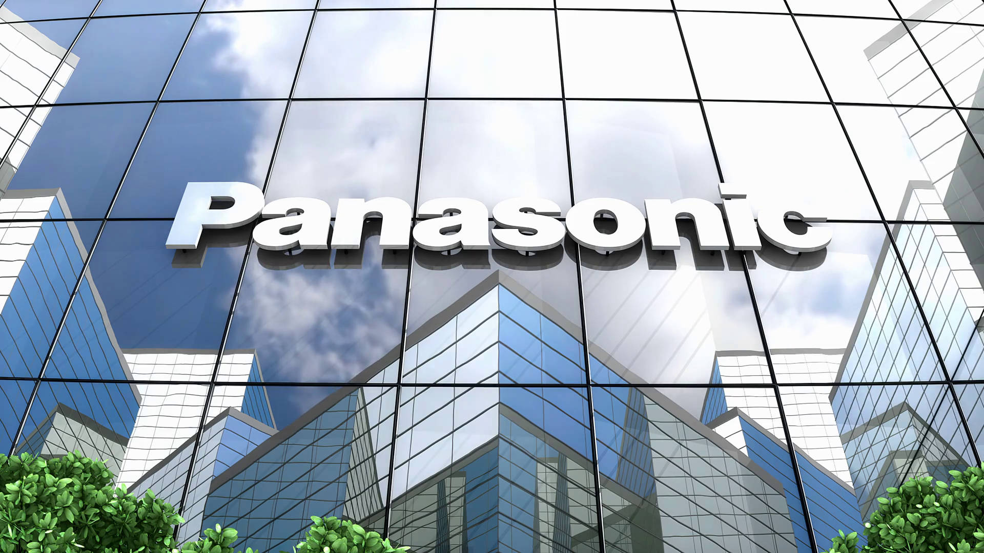 Panasonic 桌布 壁紙 — 一座現代玻璃摩天大樓，帶有大型Panasonic標誌，反射出明亮的藍天和蓬鬆的白雲。