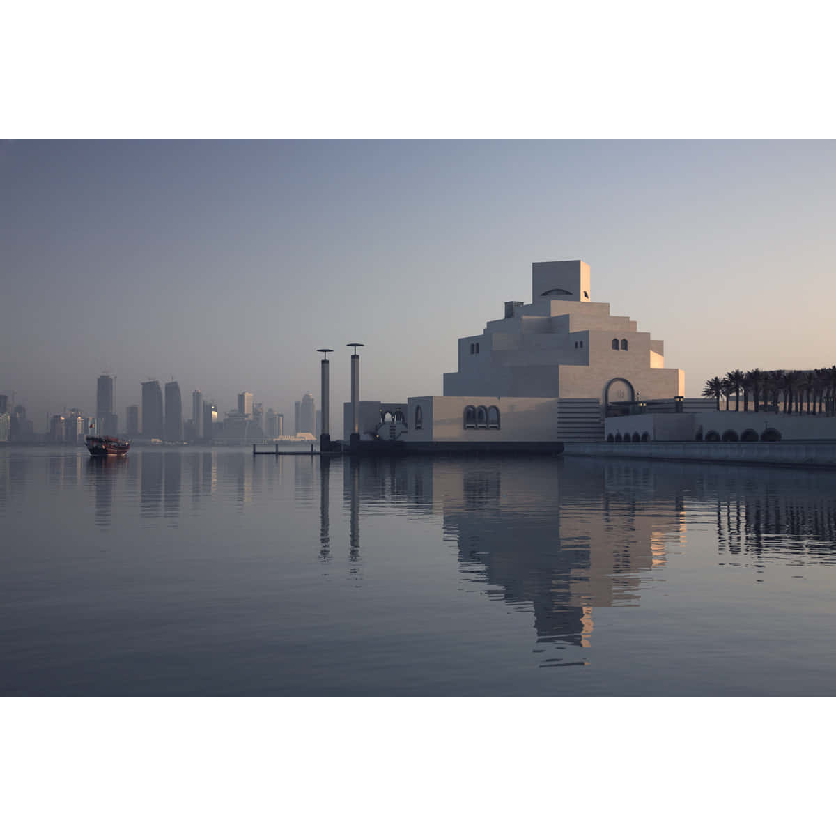 Museum Of Islamic Art 桌布 壁紙 — 一座現代白色博物館，採用階梯式建築，在黎明時分完美倒映在平靜的水面上，背景是城市天際線。
