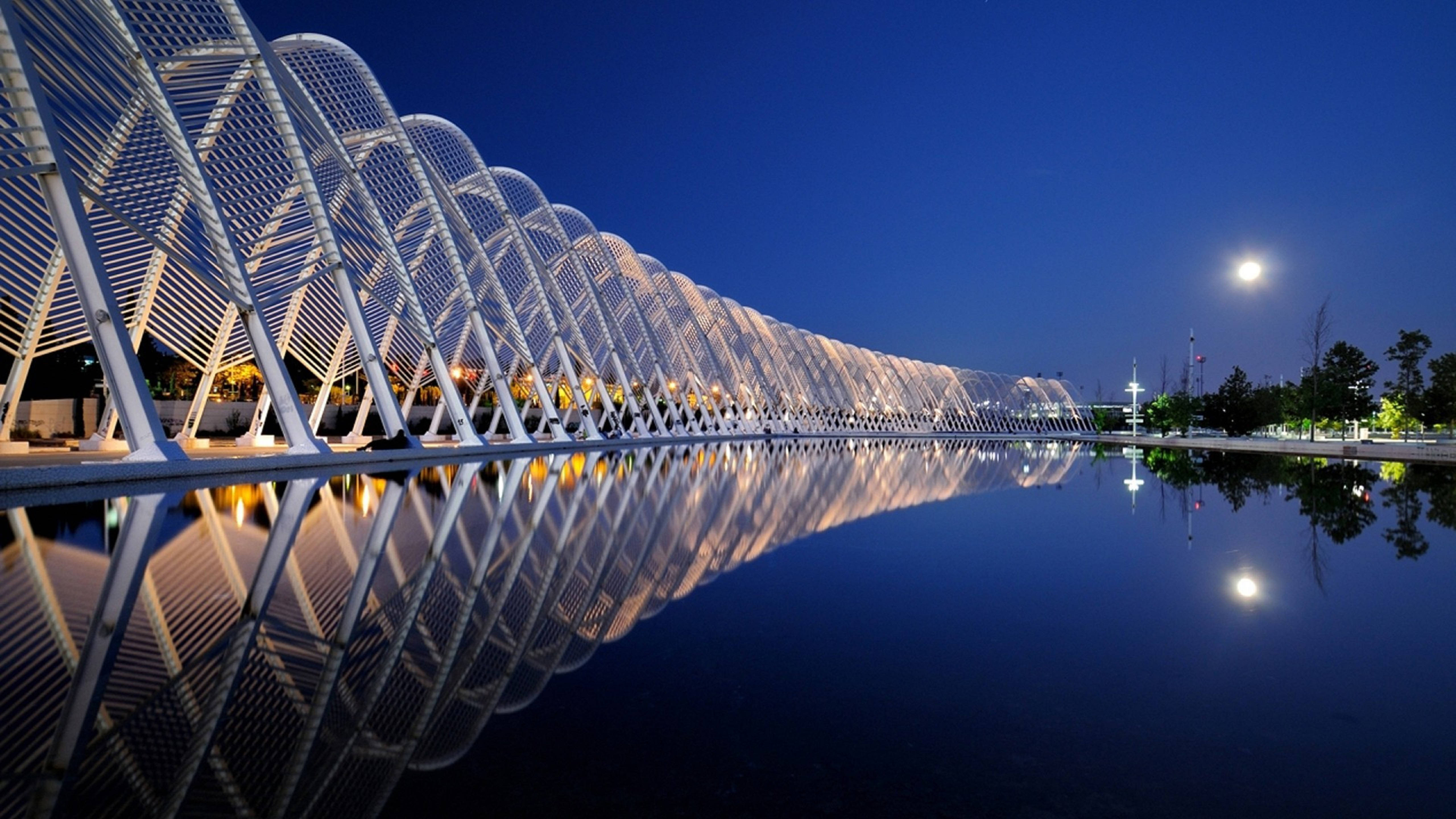 Architecture 桌布 壁紙 — 一座現代白色格子橋在月光下發光，其對稱倒影在黃昏的平靜水面上完美閃爍。