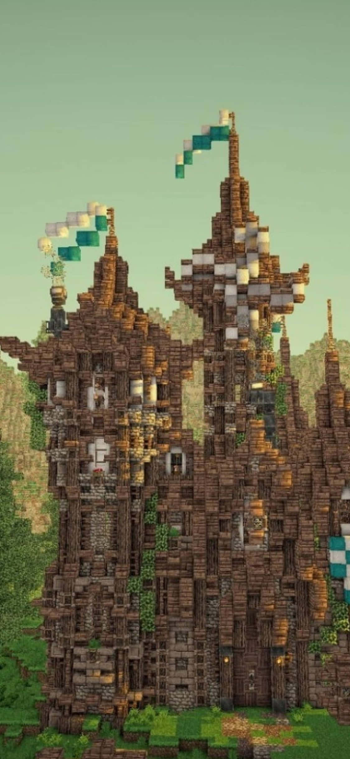 iPhone Xs Minecraft 桌布 壁紙 — 一座由棕色方塊砌成、高聳的像素化城堡，帶有綠色藤蔓和青綠色旗幟，背景是柔和的綠色天空。