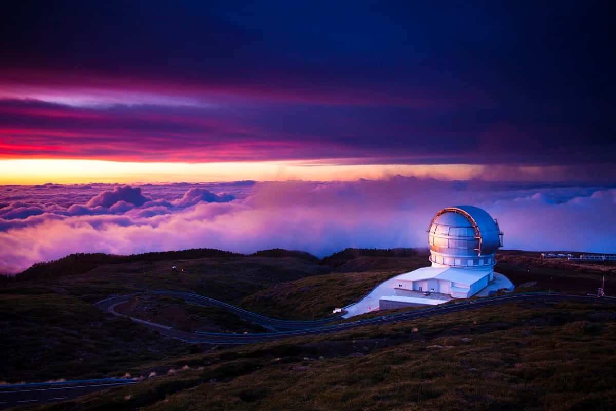 Observatory 桌布 壁紙 — 一座白色天文台坐落在山頂上，在日落時分，在紫色、橙色和粉紅色雲彩構成的戲劇性天空映襯下閃閃發光。