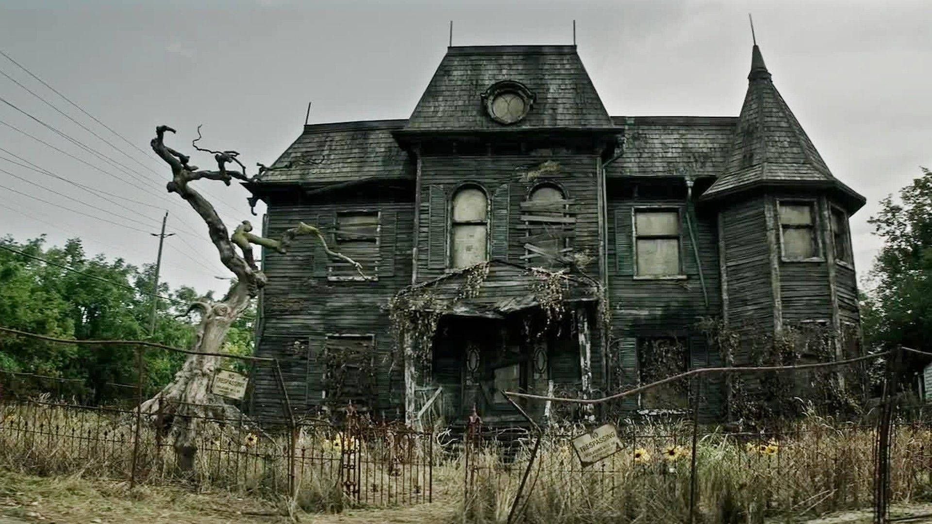 haunted 桌布 壁紙 — 一座破敗的維多利亞式大宅，窗戶破損，藤蔓叢生，矗立在陰沉天空下。