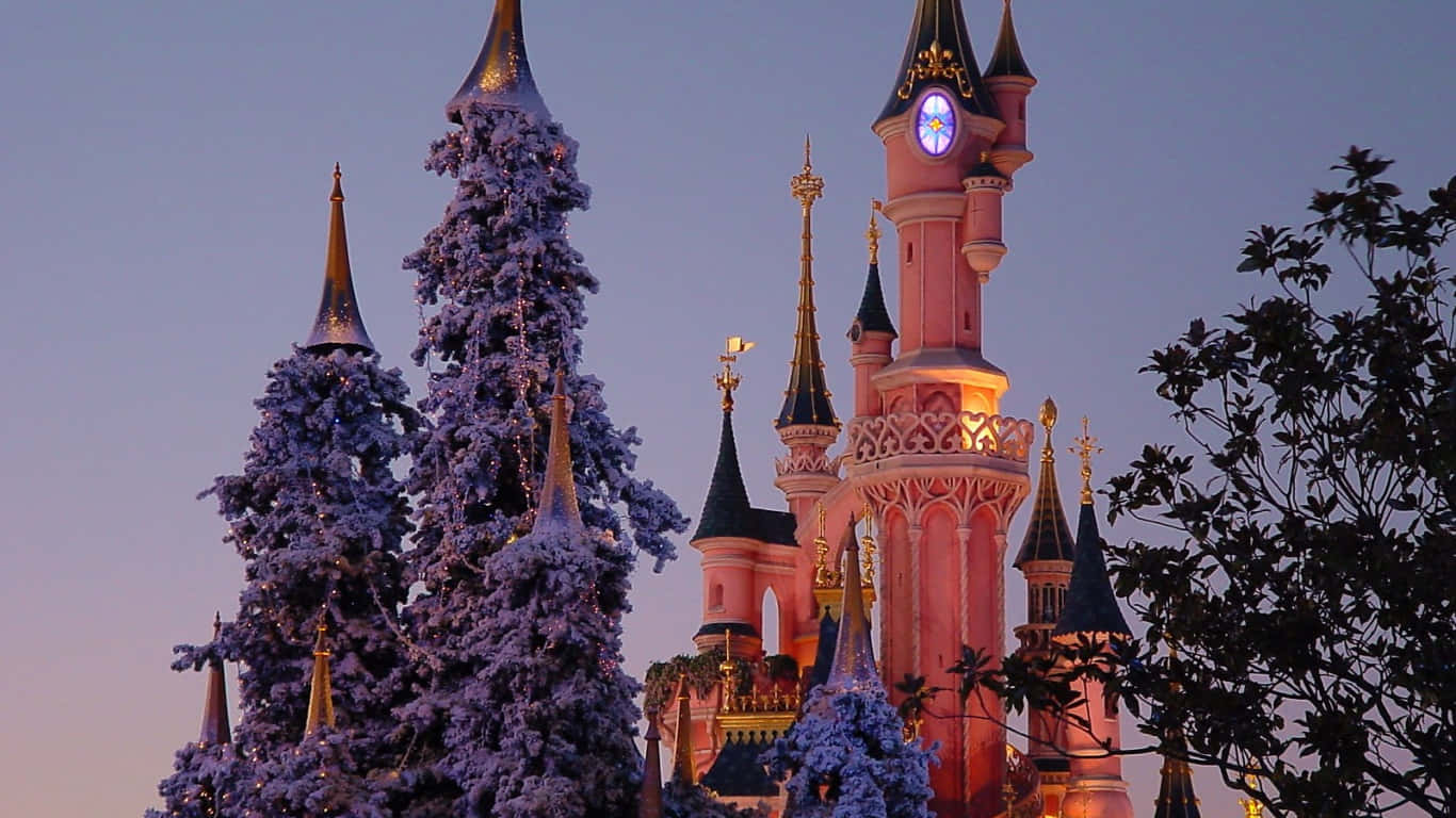 1366x768 Disney 桌布 壁紙 — 一座粉紅色城堡，閃爍的尖塔聳立在暮色天空下，旁邊是披著白雪的常青樹。