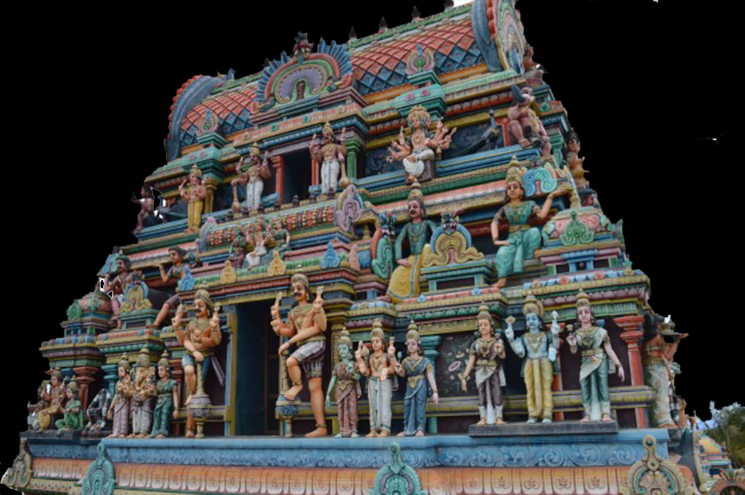 Hindu Temple 桌布 壁紙 — 一座色彩鮮豔、雕刻精美的印度教寺廟 gopuram，在黑色背景上裝飾著色彩繽紛的神靈和神話生物雕像。