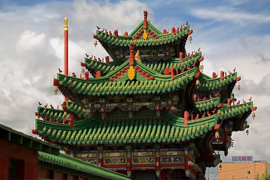 Mongolia 桌布 壁紙 — 一座色彩鮮豔的多層傳統中式寺廟，擁有綠色瓦頂和紅色裝飾點綴，天空部分多雲。