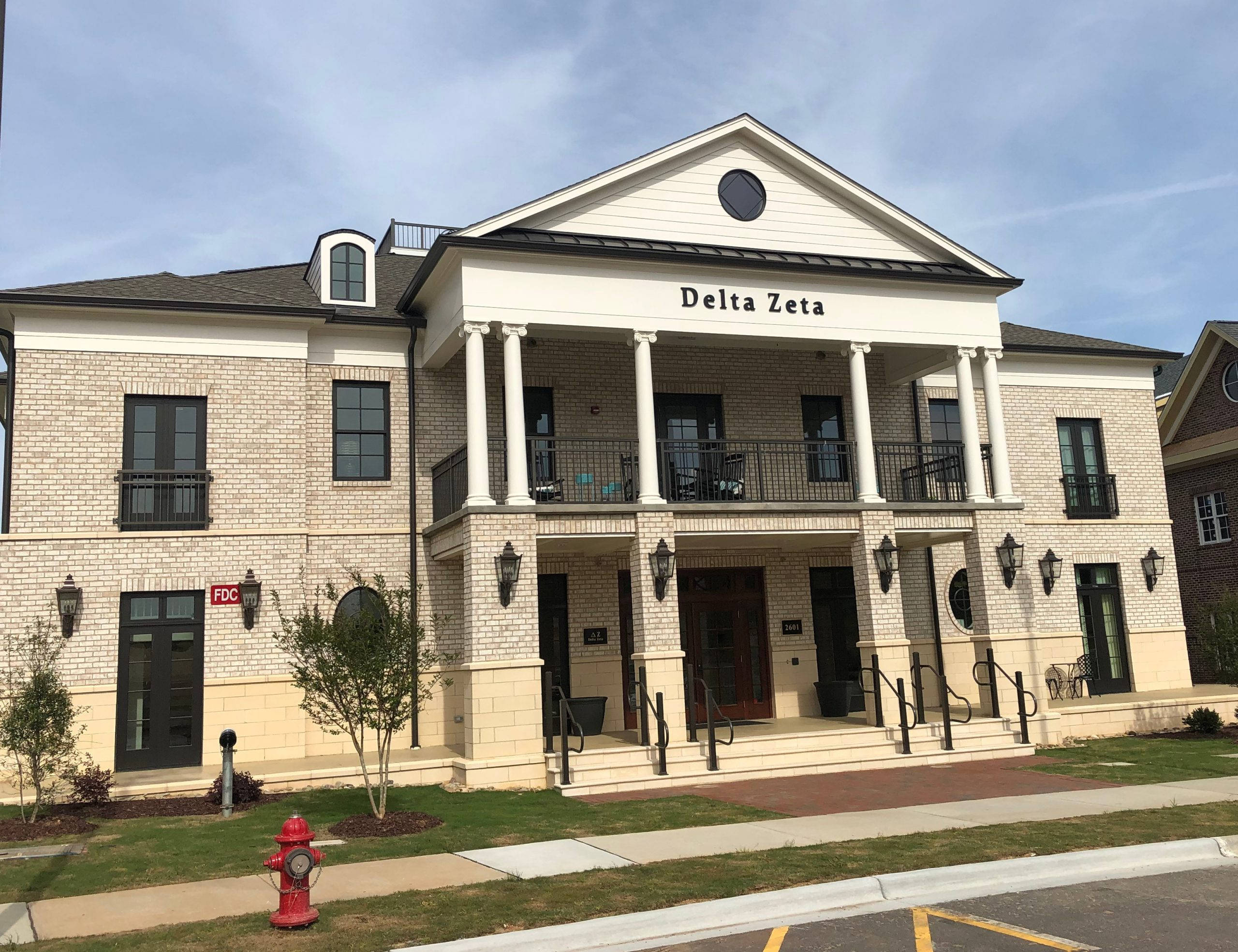 North Carolina 桌布 壁紙 — 一座莊嚴的兩層磚砌建築，帶有白色柱子和 'Delta Zeta' 標誌，在晴朗的藍天下。