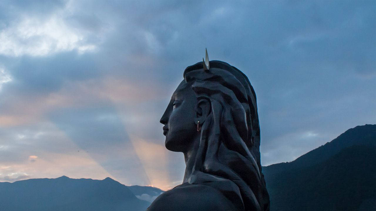 帶角女性雕像在暮色山巒前的剪影。 — 濕婆神 壁紙