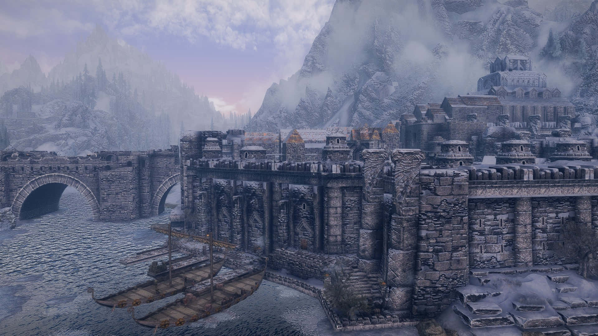 Skyrim Windhelm 桌布 壁紙 — 一座被雪覆蓋的中世紀堡壘城市，坐落在懸崖上，有石橋和船隻停泊在冰冷的水域中，天空籠罩著薄霧的暮色。