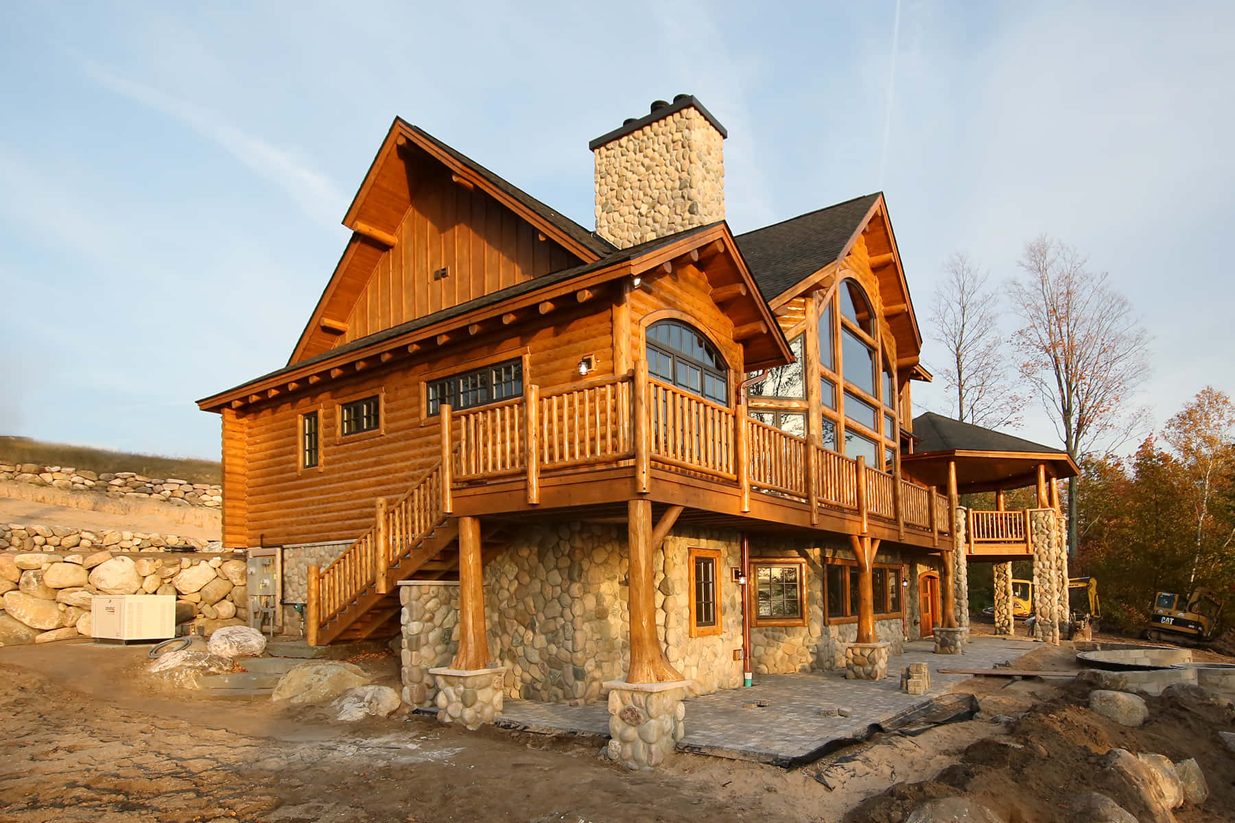 Log Cabin 桌布 壁紙 — 一座質樸的木屋，擁有石頭地基和木製陽台，在黃金時段清澈的藍天下矗立。