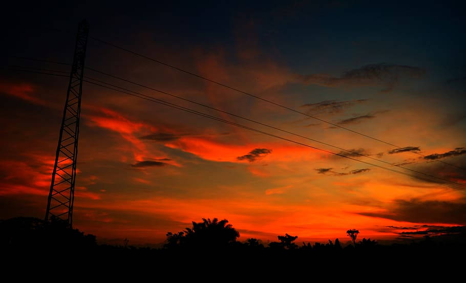 Sunset Aesthetic 桌布 壁紙 — 一座輸電塔在帶有烏雲的火紅橙色和紅色日落天空下呈現剪影。