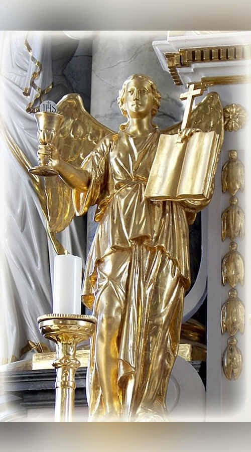 Sacrament 桌布 壁紙 — 一座金色天使雕像在教堂中手持聖杯和書本，在柔和光線下於蠟燭旁閃耀。
