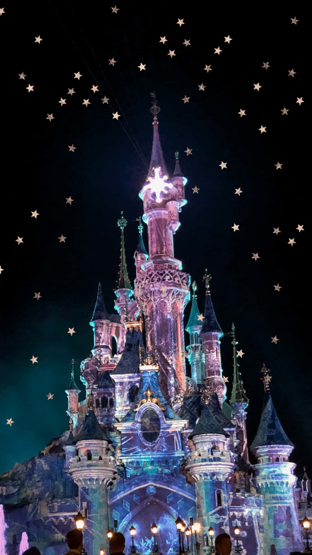 Disney Castle 桌布 壁紙 — 一座雄偉的城堡在繁星點點的夜空下被鮮豔的燈光照亮。