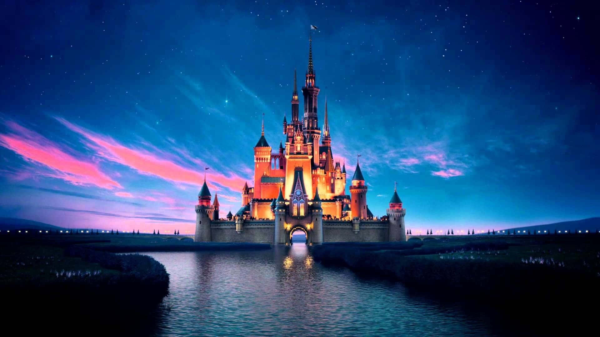 Aesthetic Disney Laptop 桌布 壁紙 — 一座雄偉的城堡在繁星點點的暮色天空下溫暖地發光，粉紅色和藍色的雲彩倒映在平靜的水面上。
