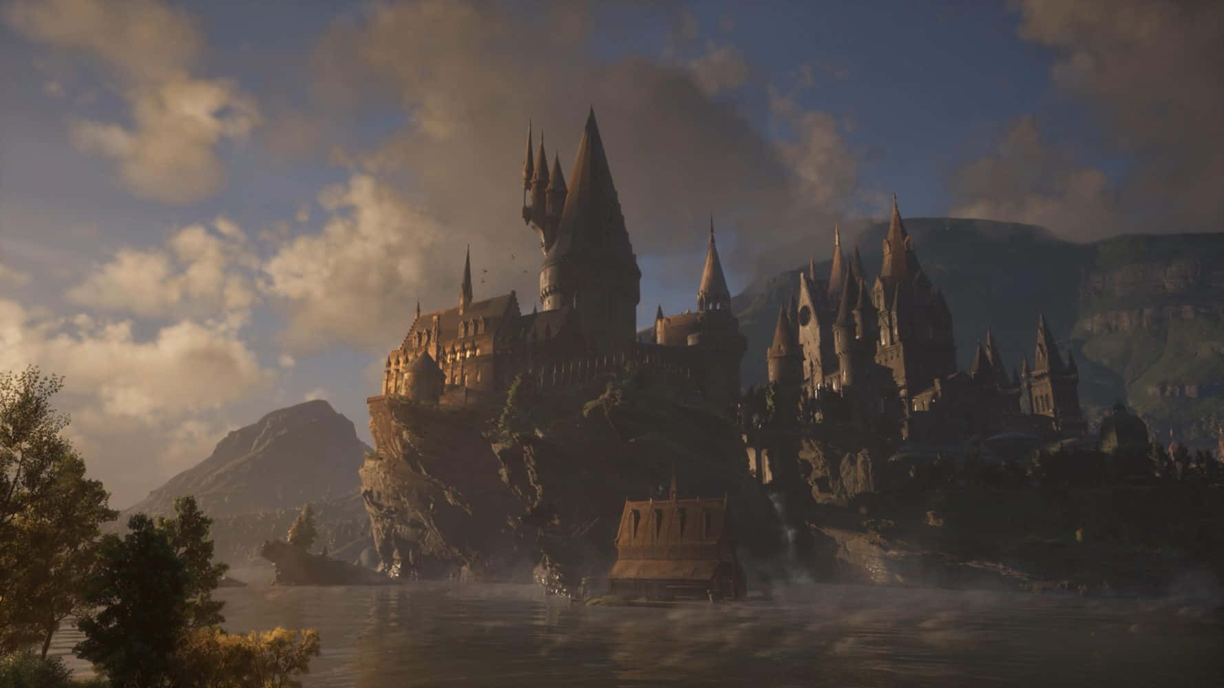 Hogsmeade 桌布 壁紙 — 一座雄偉的城堡坐落在懸崖邊，俯瞰著霧氣瀰漫的湖泊，背景是山脈，天空多雲。
