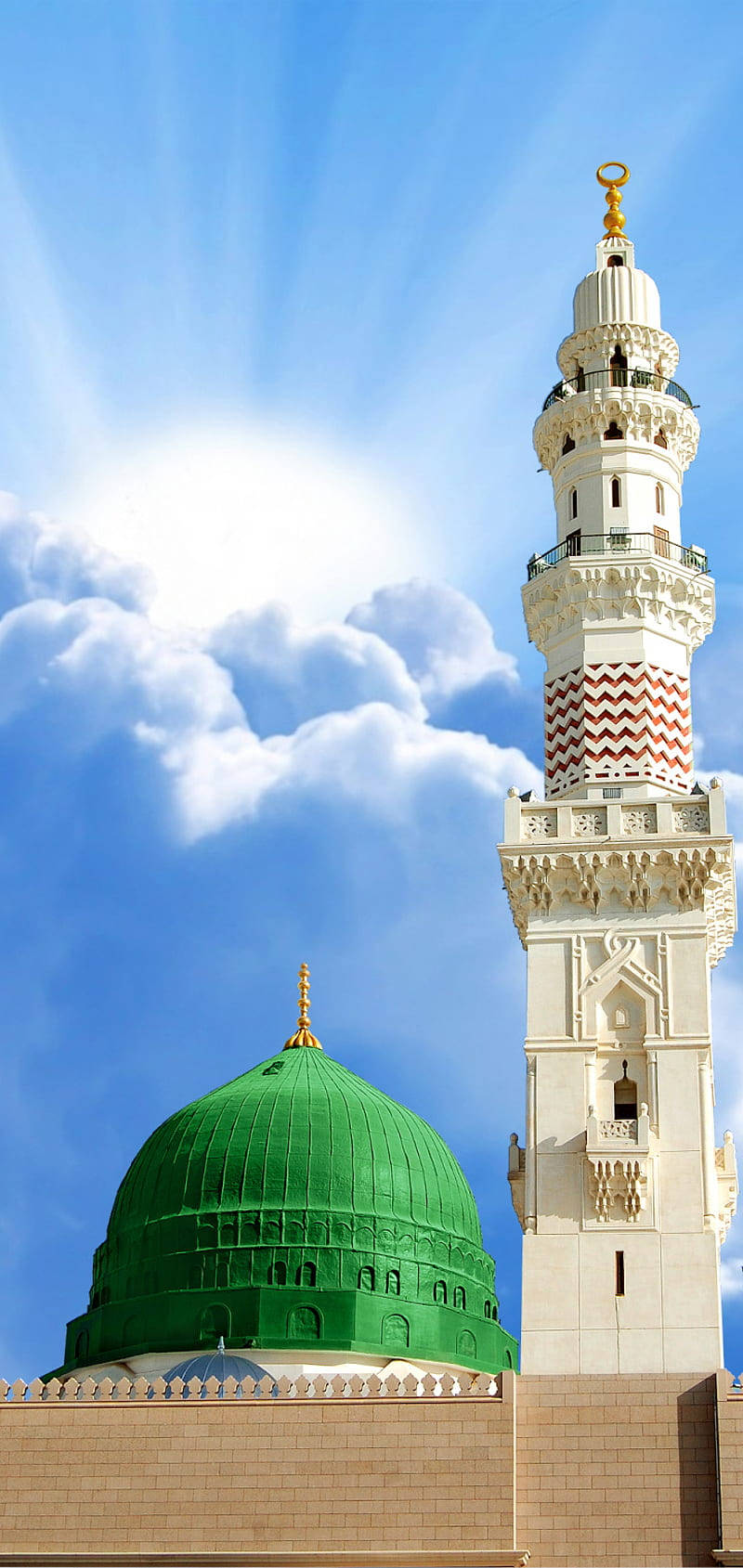 Madina 桌布 壁紙 — 一座雄偉的清真寺，擁有充滿活力的綠色圓頂和華麗的白色宣禮塔，在藍天白雲的映襯下高高聳立。