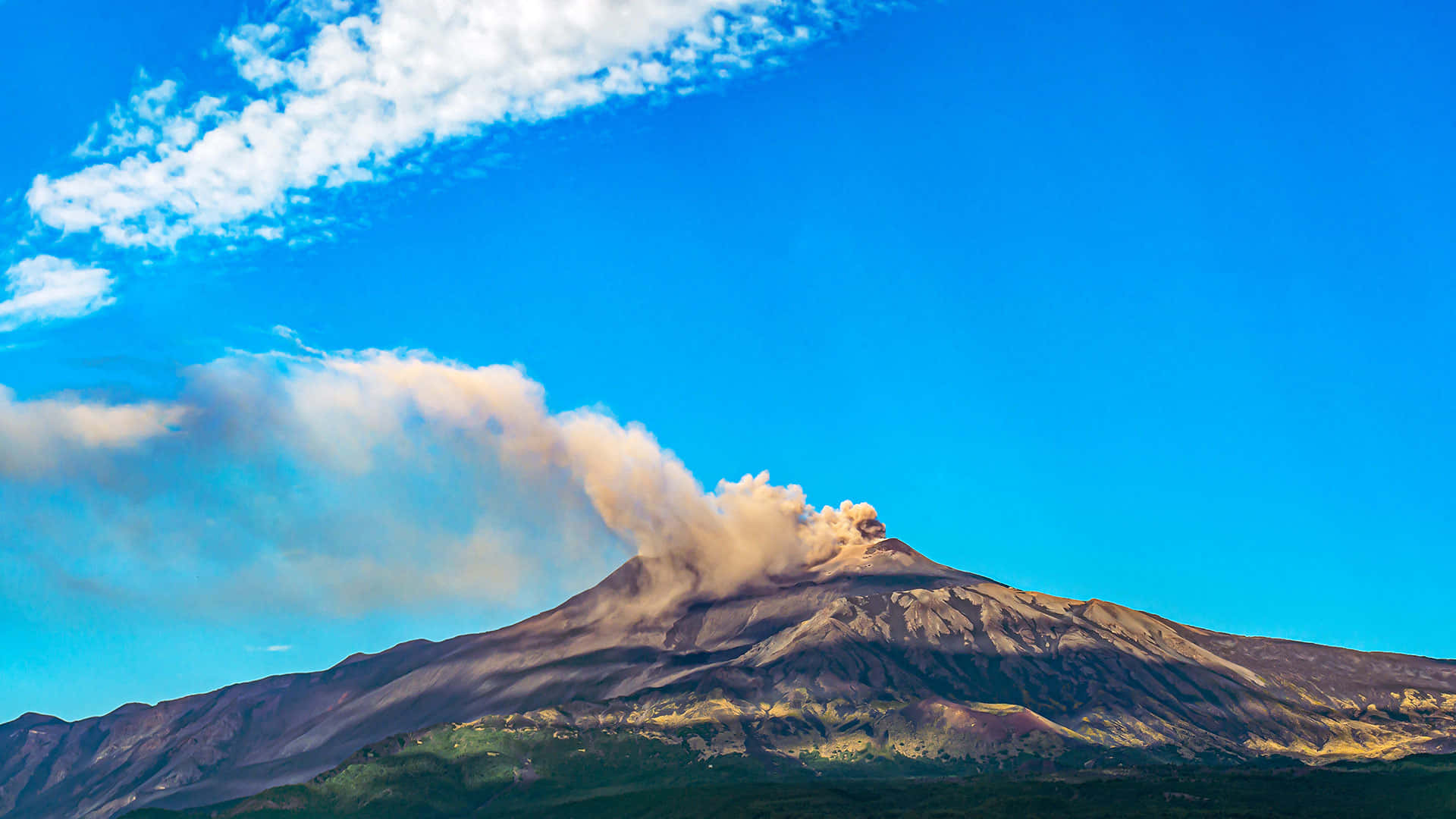 Volcano 桌布 壁紙 — 一座雄偉的火山爆發，濃密的火山灰羽狀雲在藍天白雲的背景下升起。