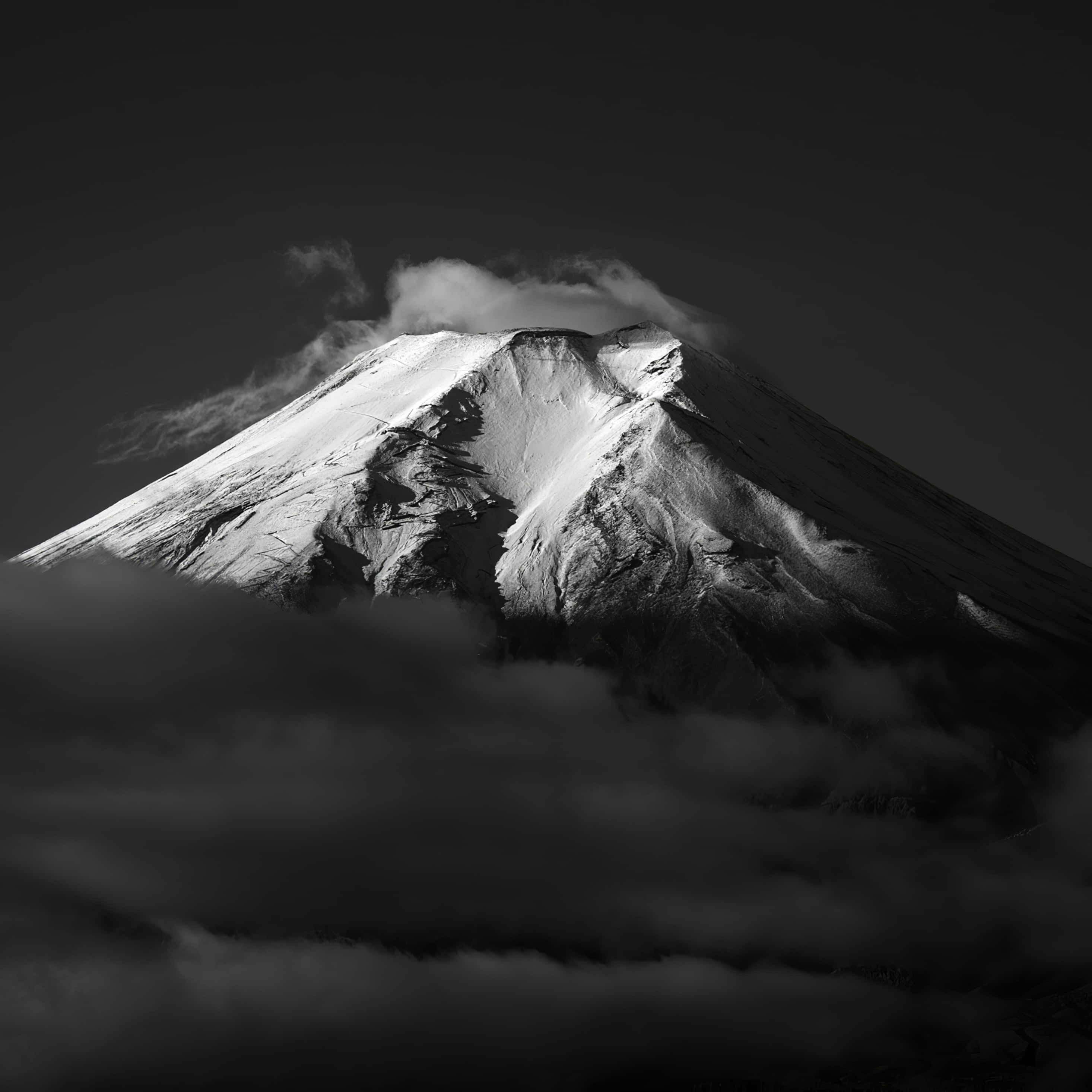 富士山 桌布 壁紙 — 一座雄偉的雪山刺穿烏雲，呈現戲劇性的黑白照片。