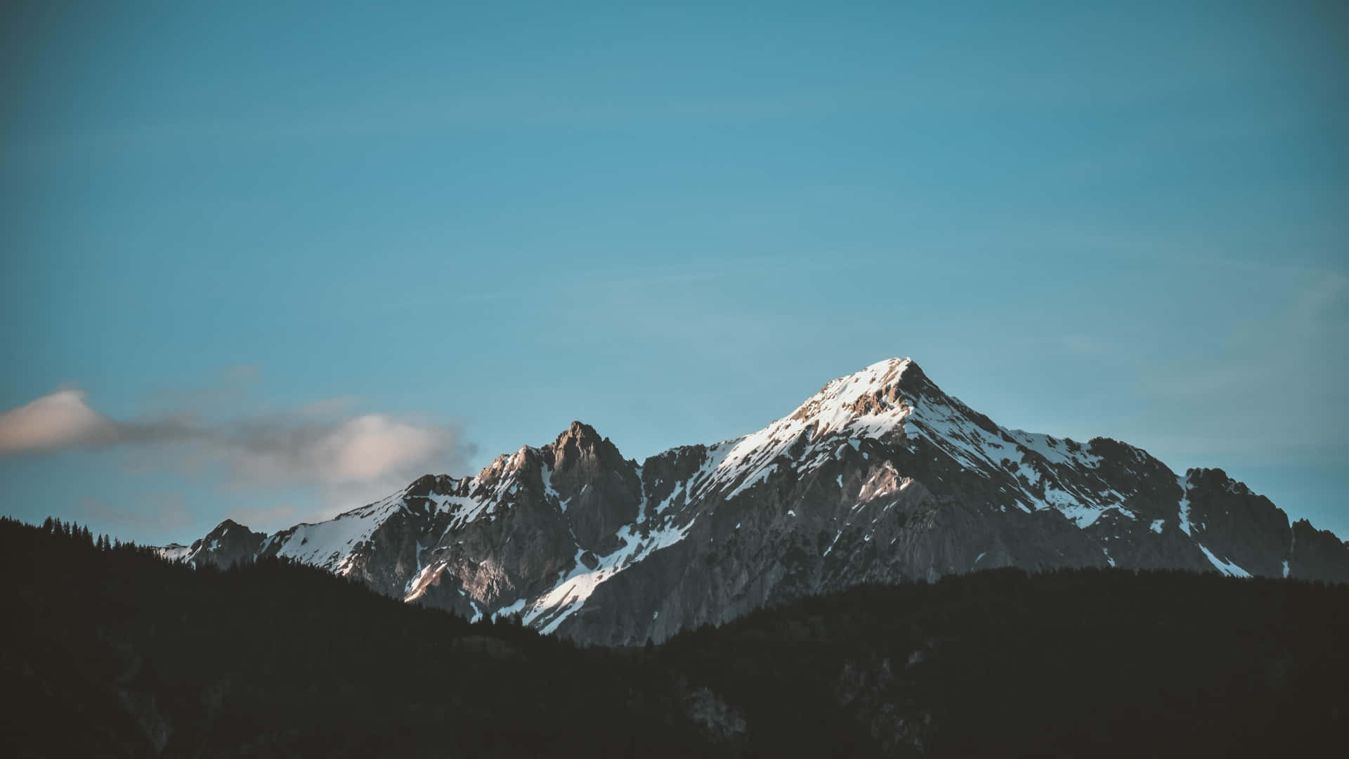 雪山峰在清澈藍天下，雲朵飄浮。 — 5K 壁紙