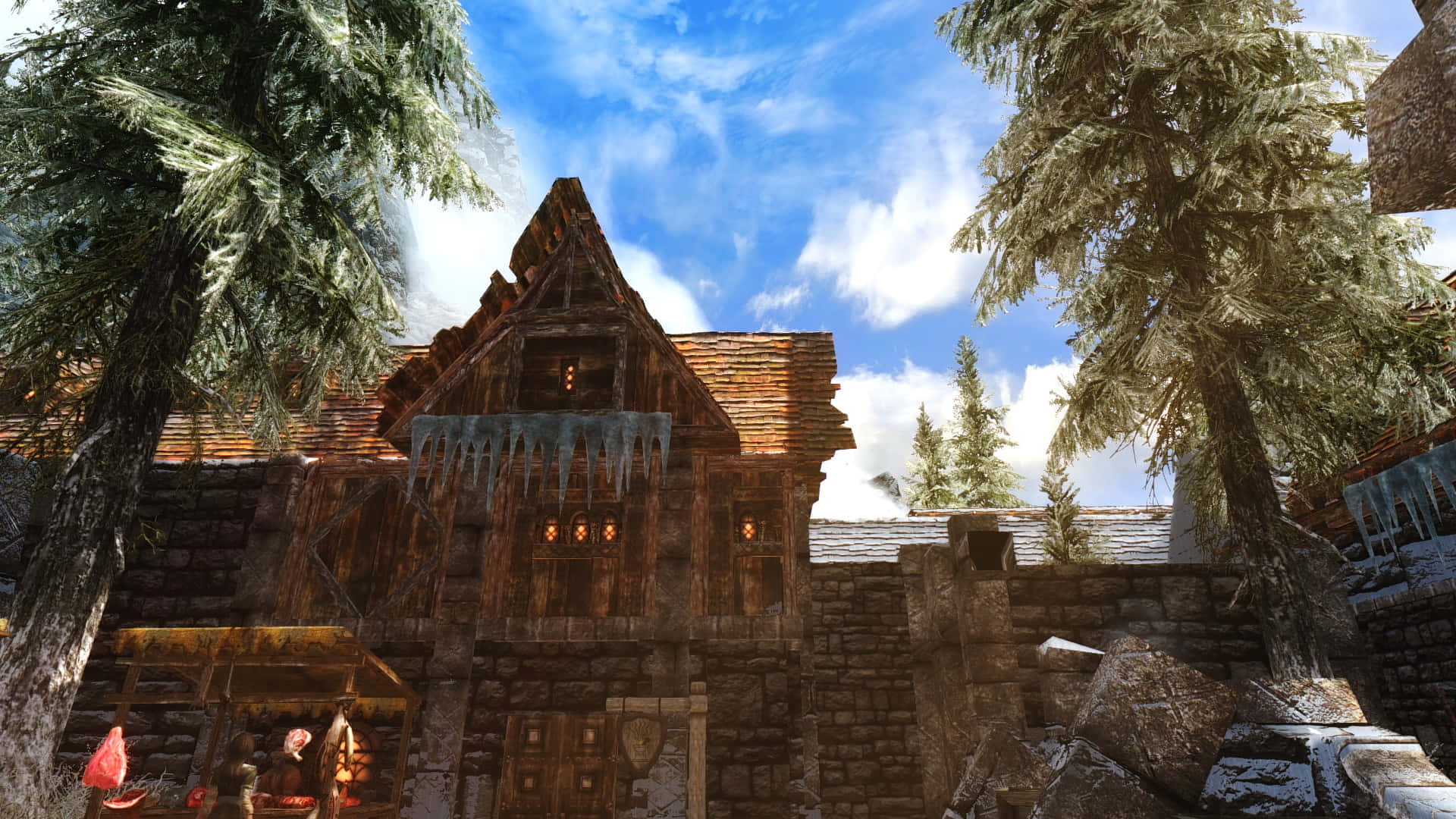 Skyrim Windhelm 桌布 壁紙 — 一座風化的木屋，屋頂掛著冰柱，周圍是高聳的松樹，在明亮的藍天下。