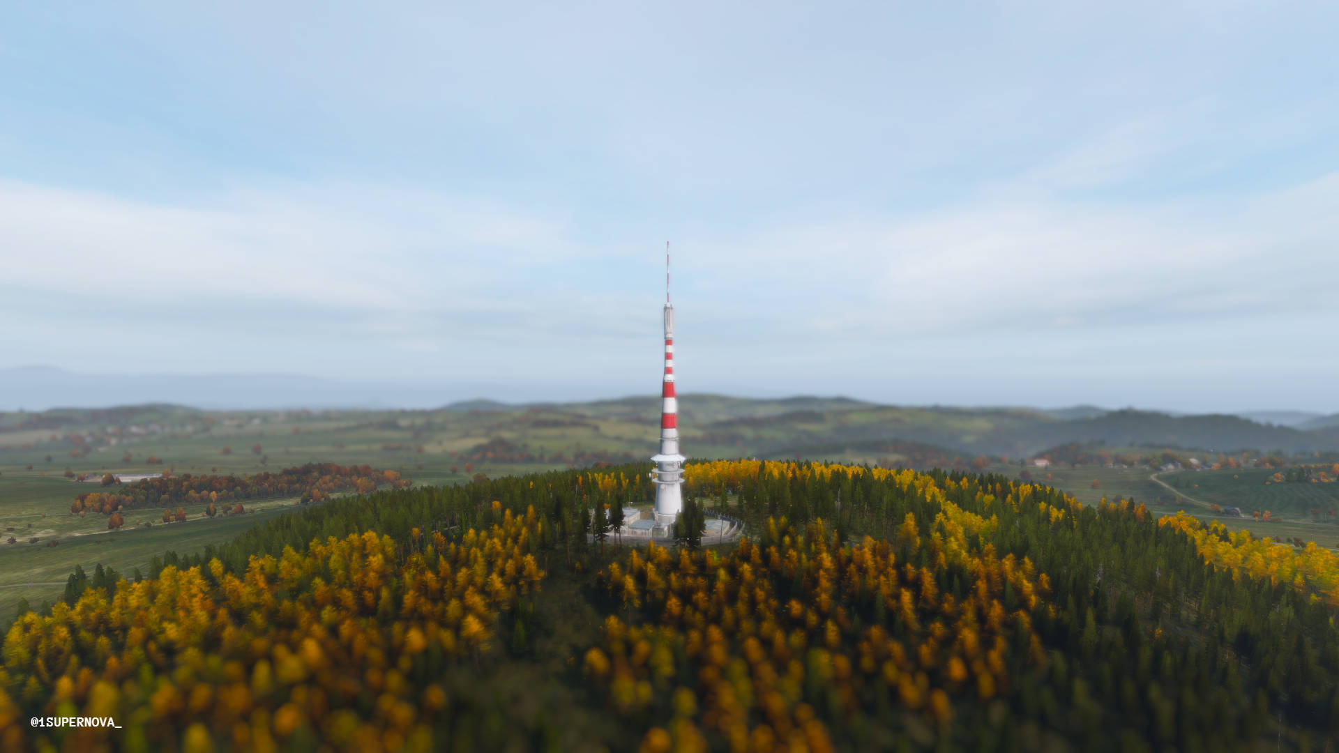 DayZ 桌布 壁紙 — 一座高大的紅白條紋塔矗立在森林覆蓋的山丘上，周圍是秋日的樹木，天空柔和湛藍。