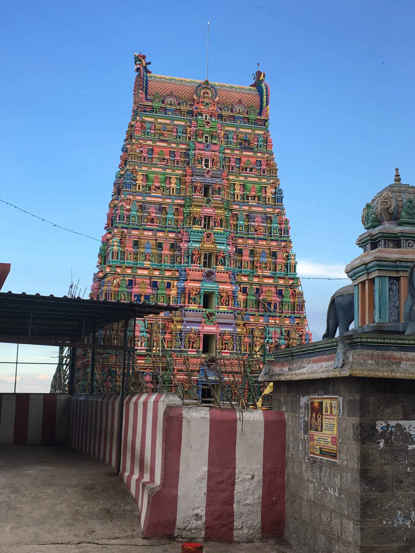 Hindu Temple 桌布 壁紙 — 一座高聳、色彩繽紛的印度教寺廟 gopuram 在清澈的藍天下升起，裝飾著複雜的雕塑和彩色瓷磚。
