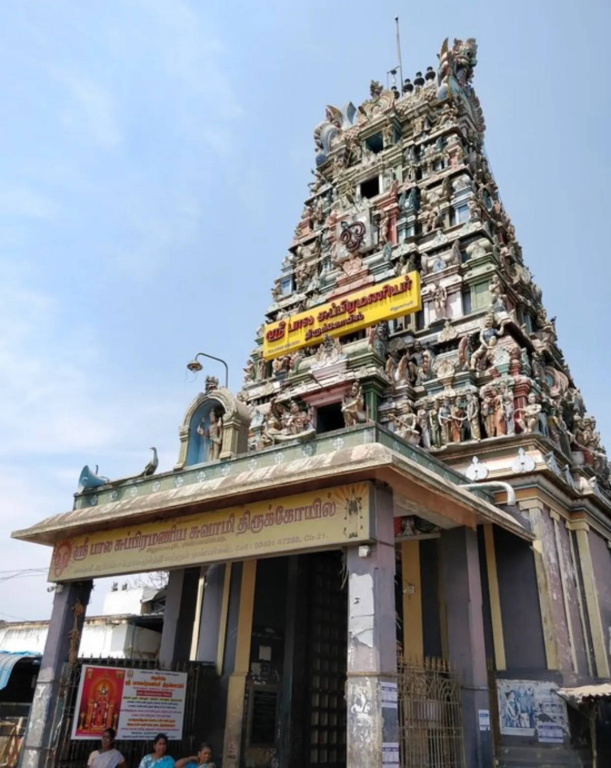 India 桌布 壁紙 — 一座高聳、雕刻精細的印度教寺廟塔門（gopuram）在清澈的藍天下拔地而起，裝飾著色彩繽紛的雕像和細緻的雕塑。