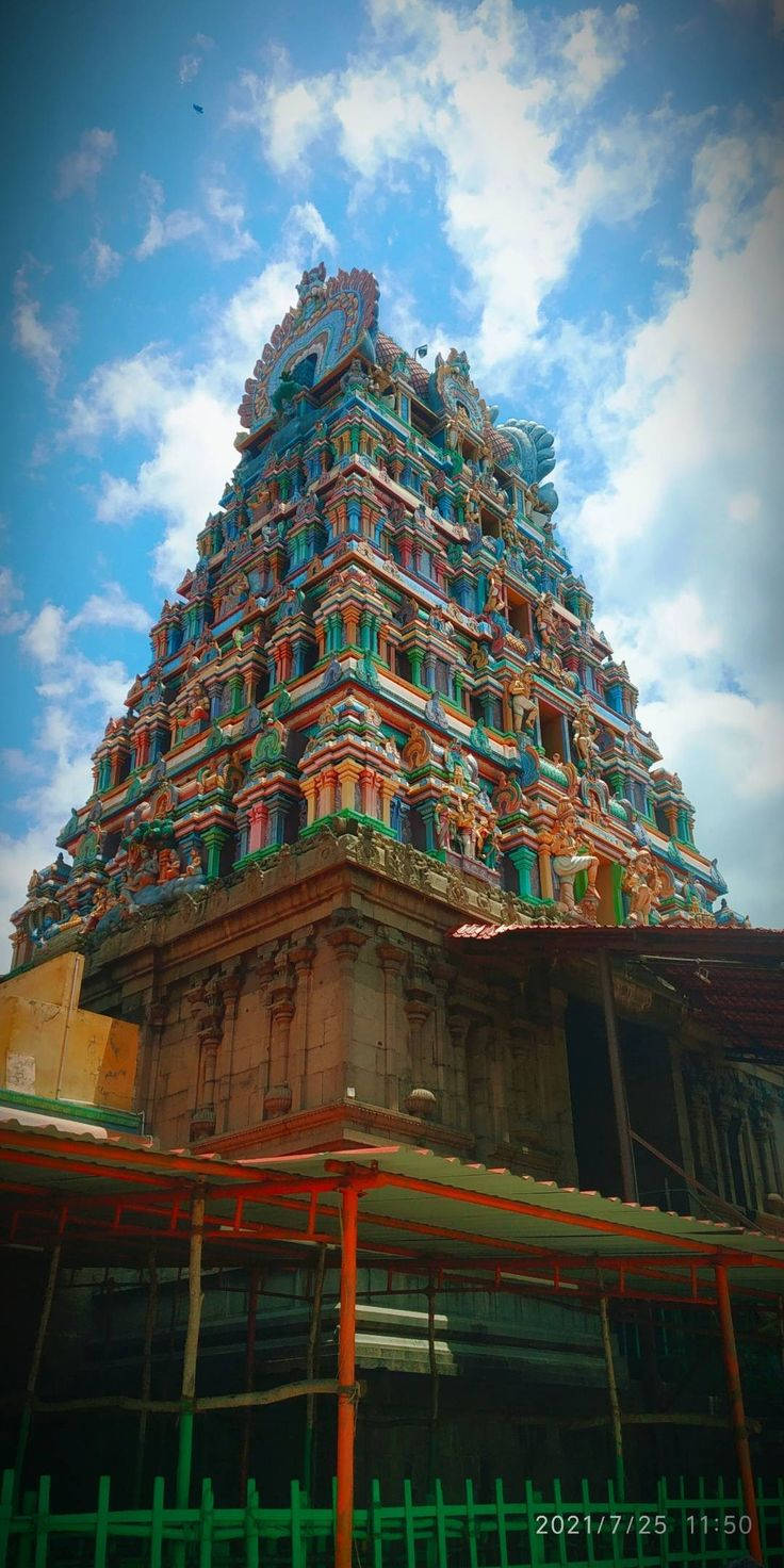 Hindu Temple 桌布 壁紙 — 一座高聳、雕刻精美的印度教寺廟 gopuram 在藍天白雲的映襯下巍然聳立。
