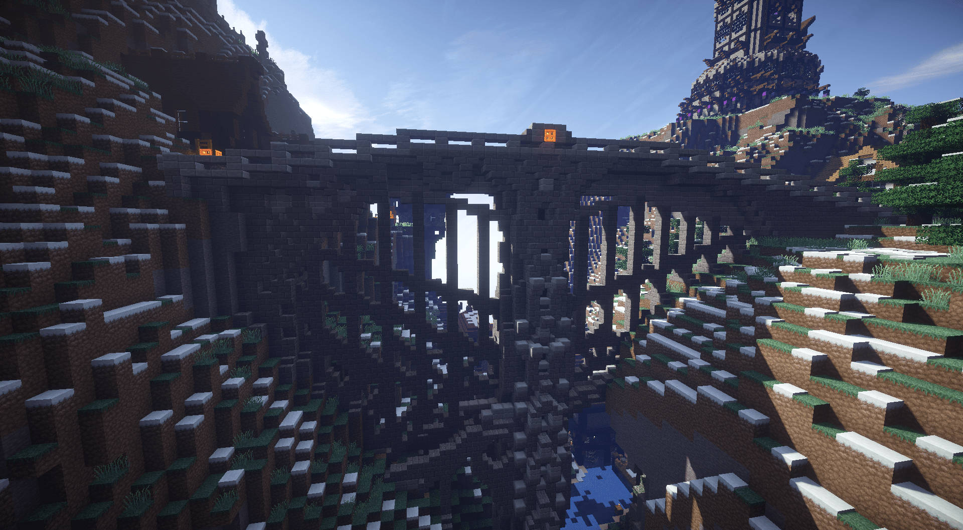 Minecraft Pc 桌布 壁紙 — 一座高聳的Minecraft橋樑橫跨深谷，兩旁是方塊狀的懸崖和發光的火炬，在清澈的藍天下。