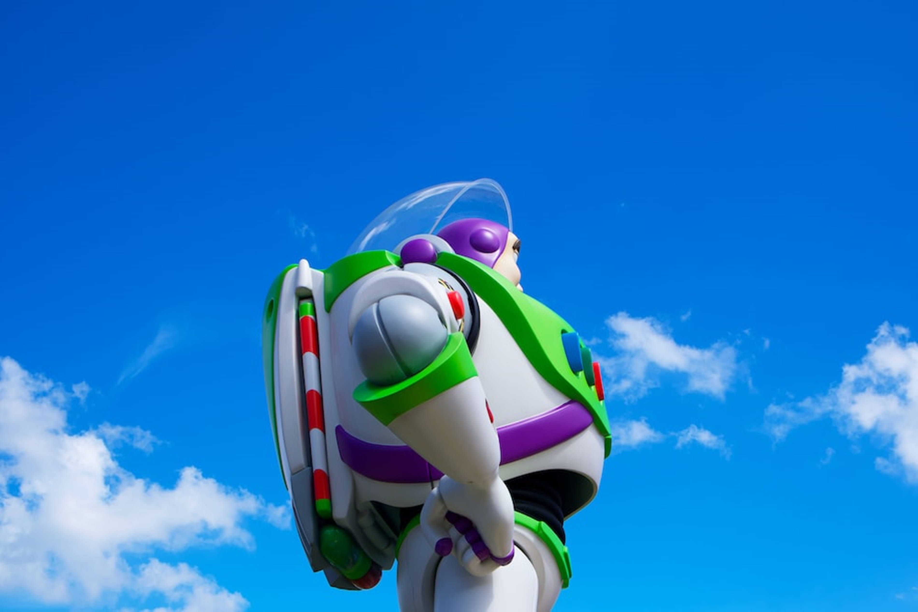 Buzz Lightyear 桌布 壁紙 — 一座高聳的巴斯光年雕像矗立在藍天白雲下。