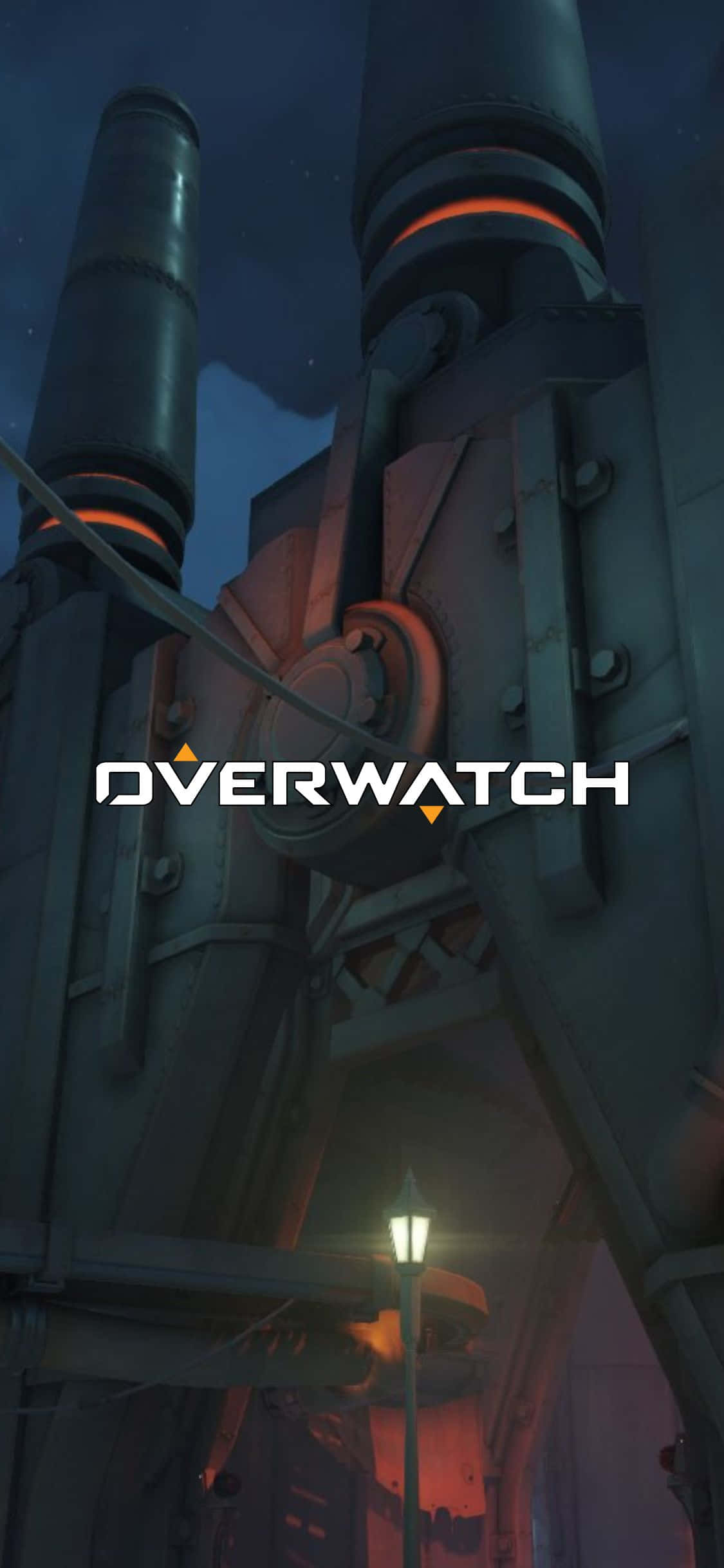 iPhone X Overwatch 桌布 壁紙 — 一座高聳的機械結構在黑暗的夜空下發出橙色光芒，下方有一盞路燈。