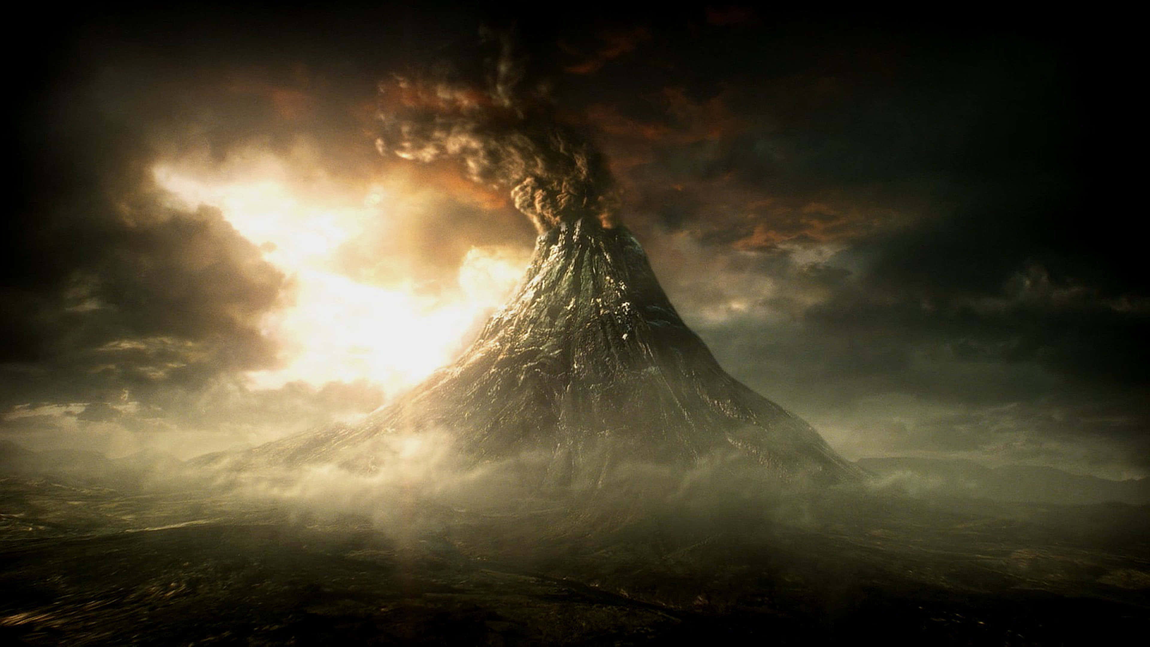 電玩遊戲 桌布 壁紙 — 一座高聳的火山在暴風雨的天空下戲劇性地噴發，金色的光芒穿透烏雲。