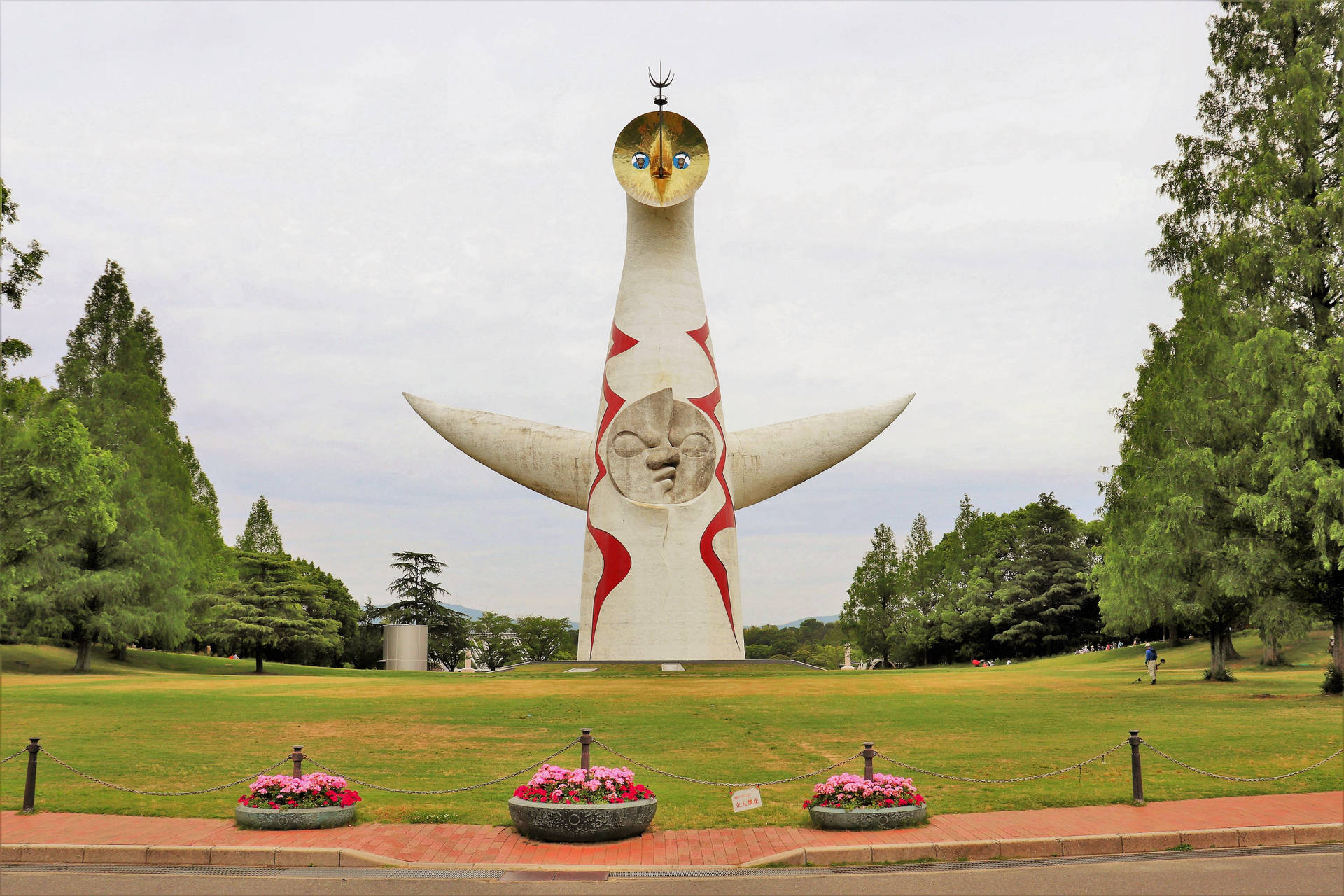 在一個有花壇和樹木的草地公園中的大型抽象雕塑。