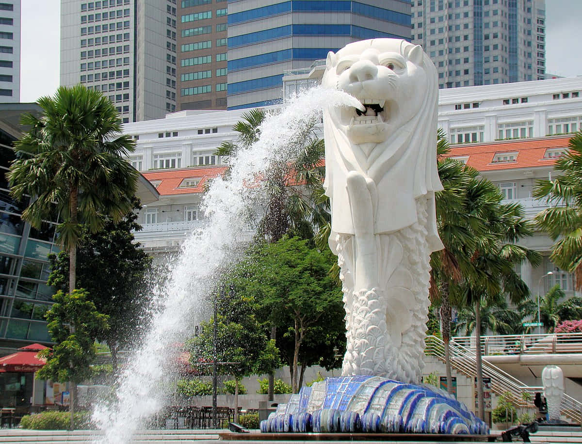 Lion Head 桌布 壁紙 — 一座高聳的白色魚尾獅雕像在繁忙的新加坡城市景觀中噴水，周圍有棕櫚樹和現代摩天大樓。
