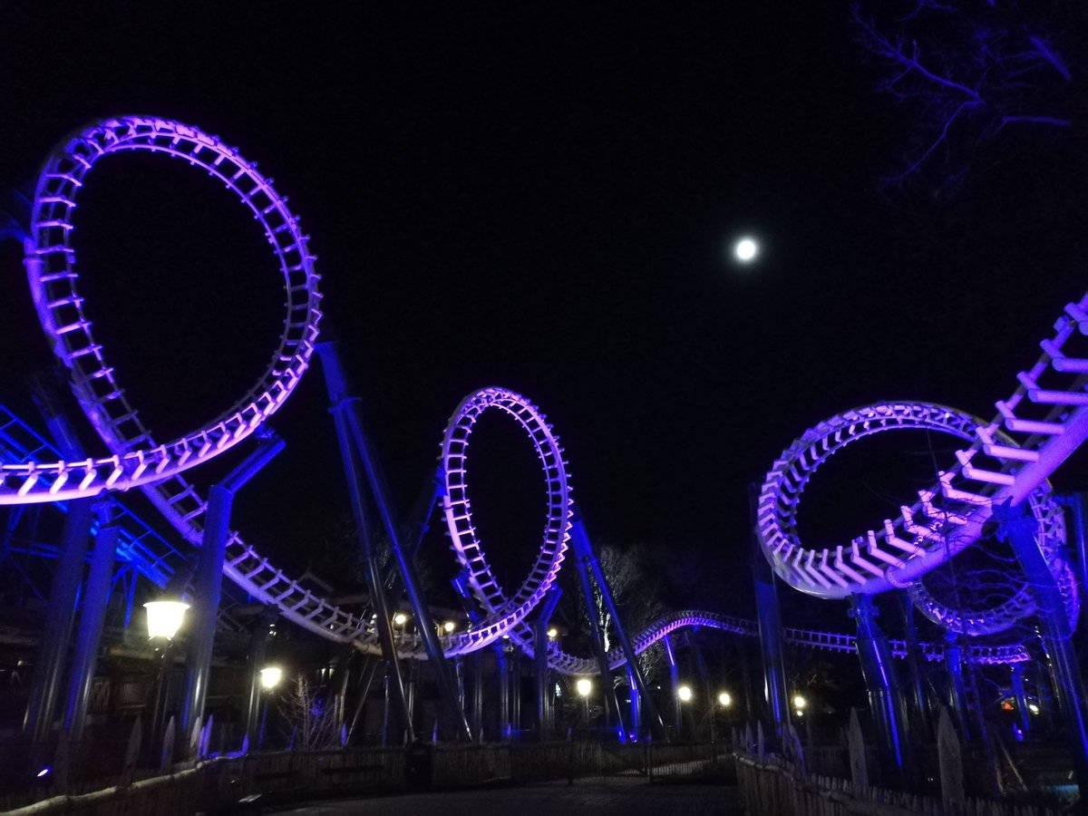 Roller Coaster 桌布 壁紙 — 一座高聳的紫色燈光雲霄飛車在沒有星星的夜空下戲劇性地盤旋，上方掛著一輪明亮的月亮。