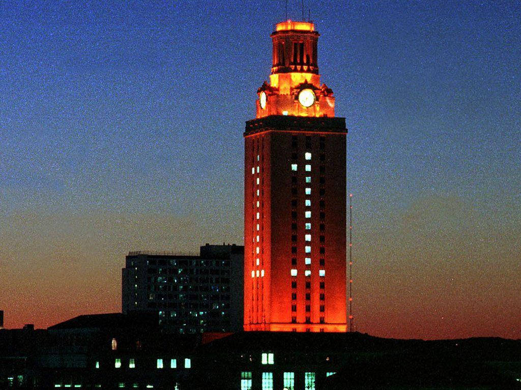Texas 桌布 壁紙 — 一座高聳的鐘樓沐浴在溫暖的橙色燈光中，矗立在帶有藍色和橙色漸變色調的暮色天空下。