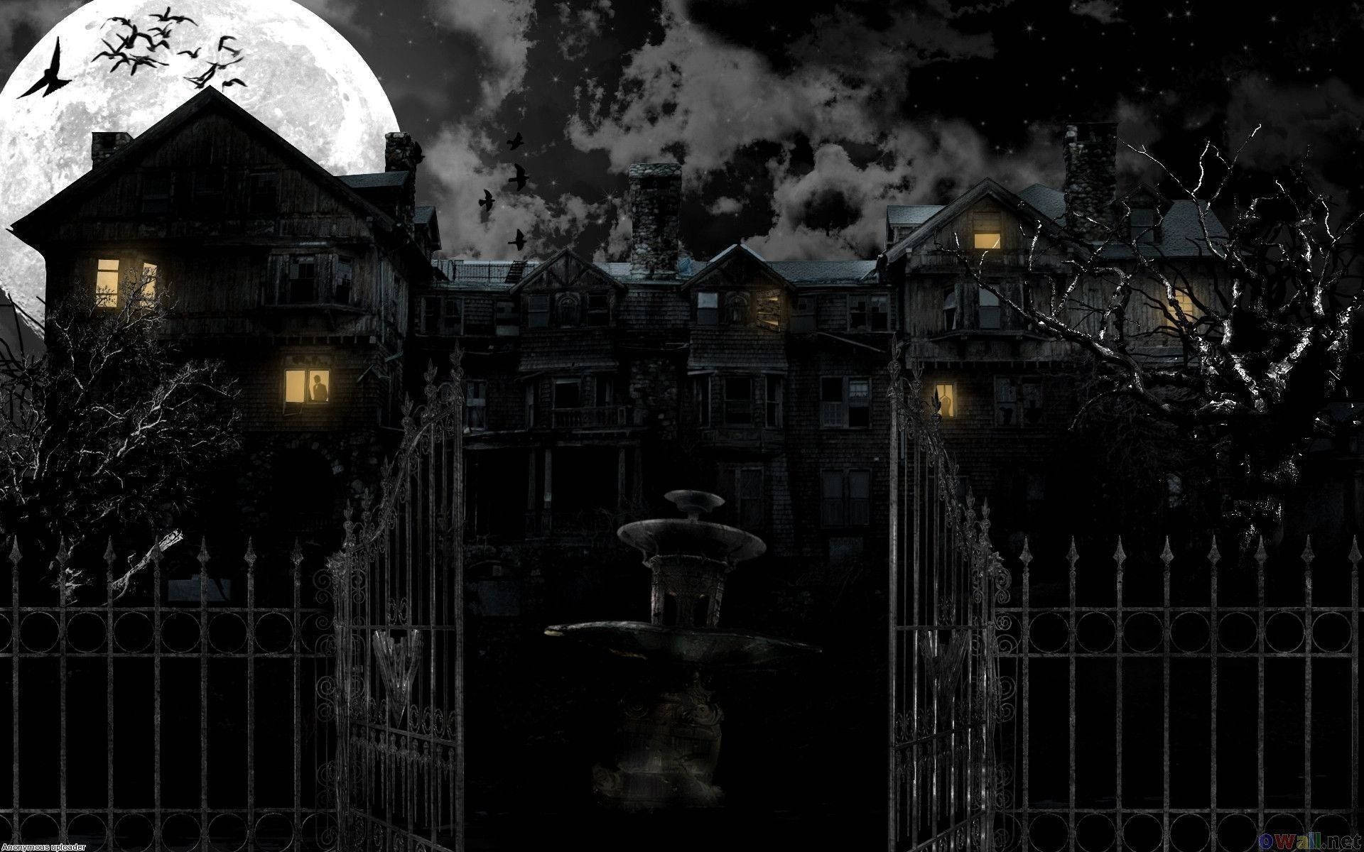 haunted 桌布 壁紙 — 一座鬼屋在滿月下，發光的窗戶和飛翔的蝙蝠映襯著黑暗多雲的天空。