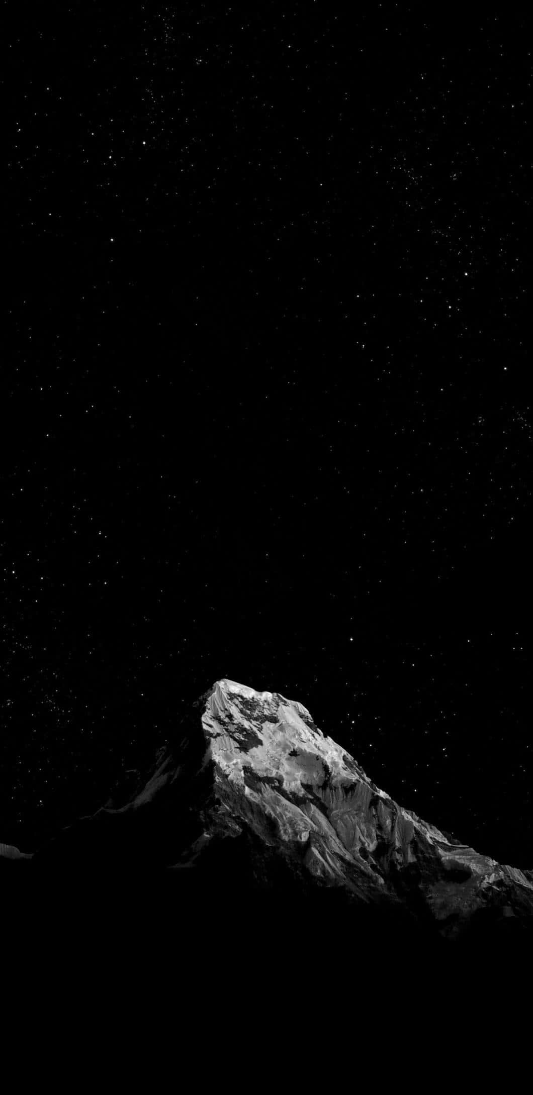 黑白 桌布 壁紙 — 一座鮮明的單色山峰在繁星滿天的夜空下聳立，帶有深邃陰影和閃耀的積雪。