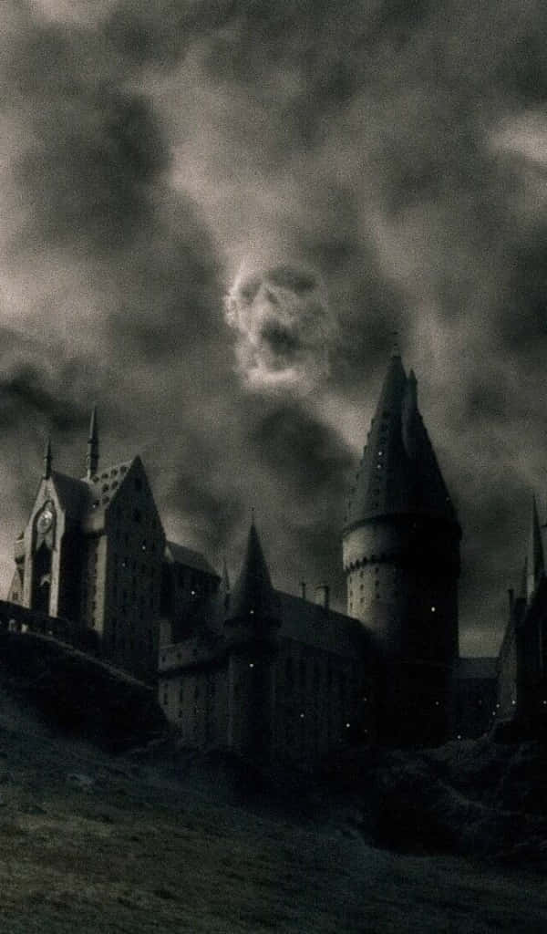 Harry Potter Black And White 桌布 壁紙 — 一座黑暗的哥德式城堡坐落在山丘上，天空風暴密佈，雲層中浮現幽靈般的面孔。