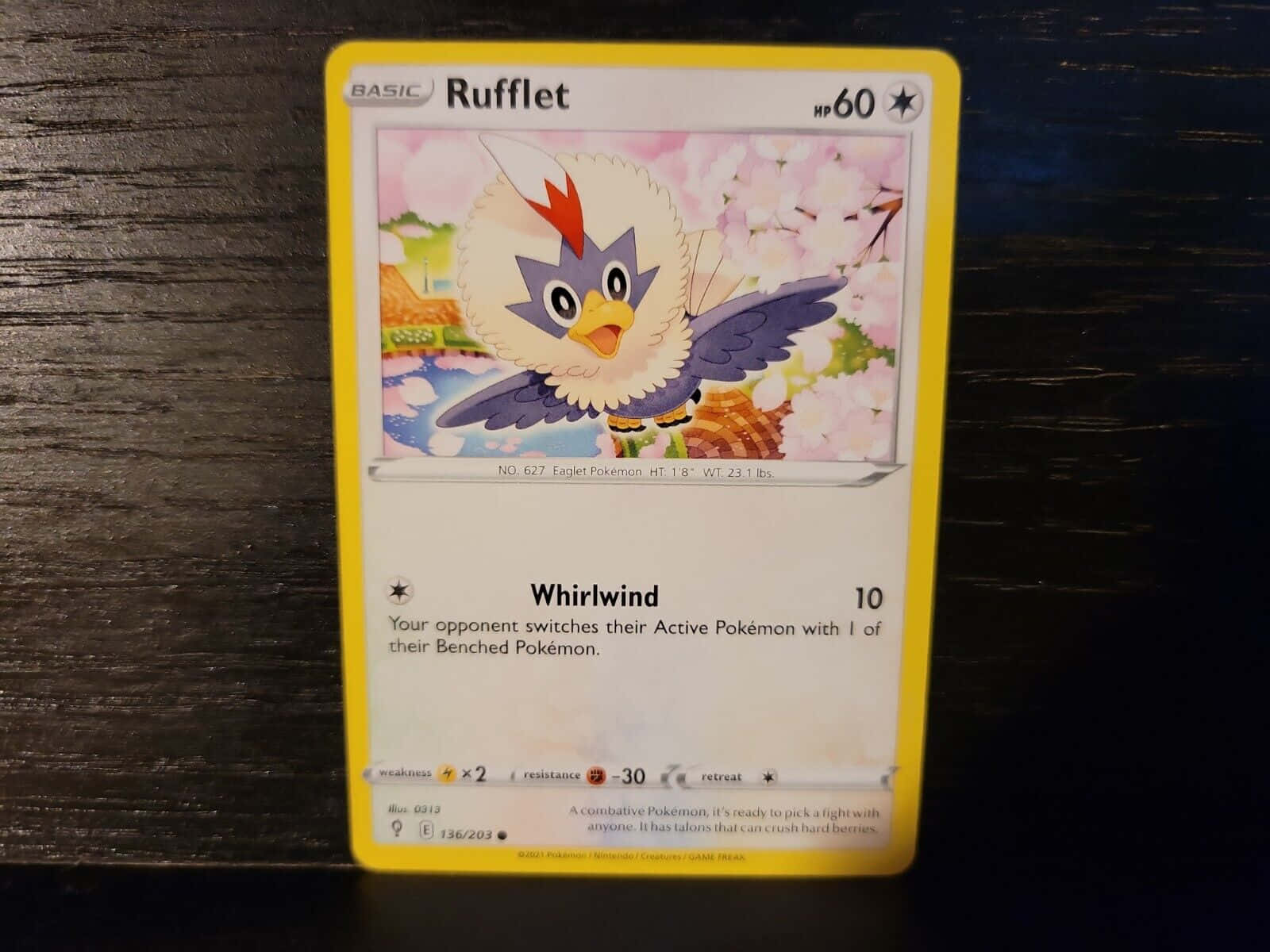 寶可夢 桌布 壁紙 — 一張 Rufflet 寶可夢卡牌放在深色木質表面上，背景有櫻花。